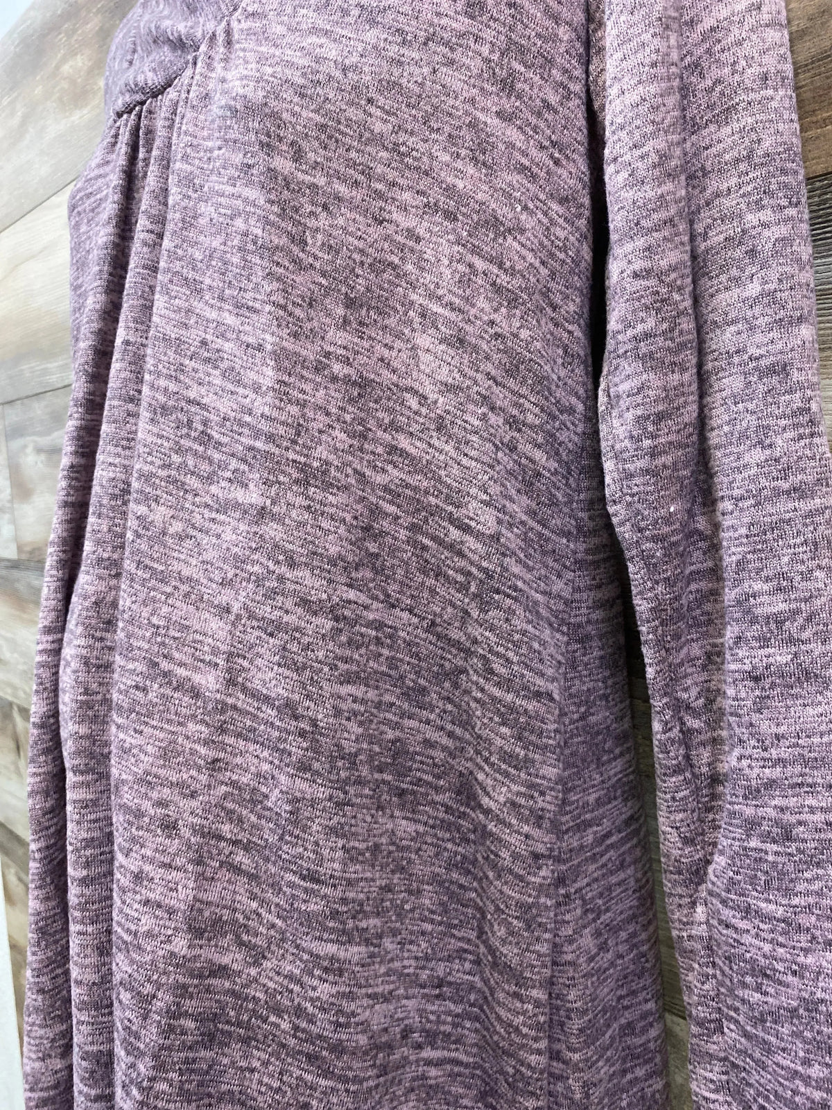 Close-up of Hello MIZ mauve shawl-collar maternity knit tunic showing gathered seam and heathered texture on wood background