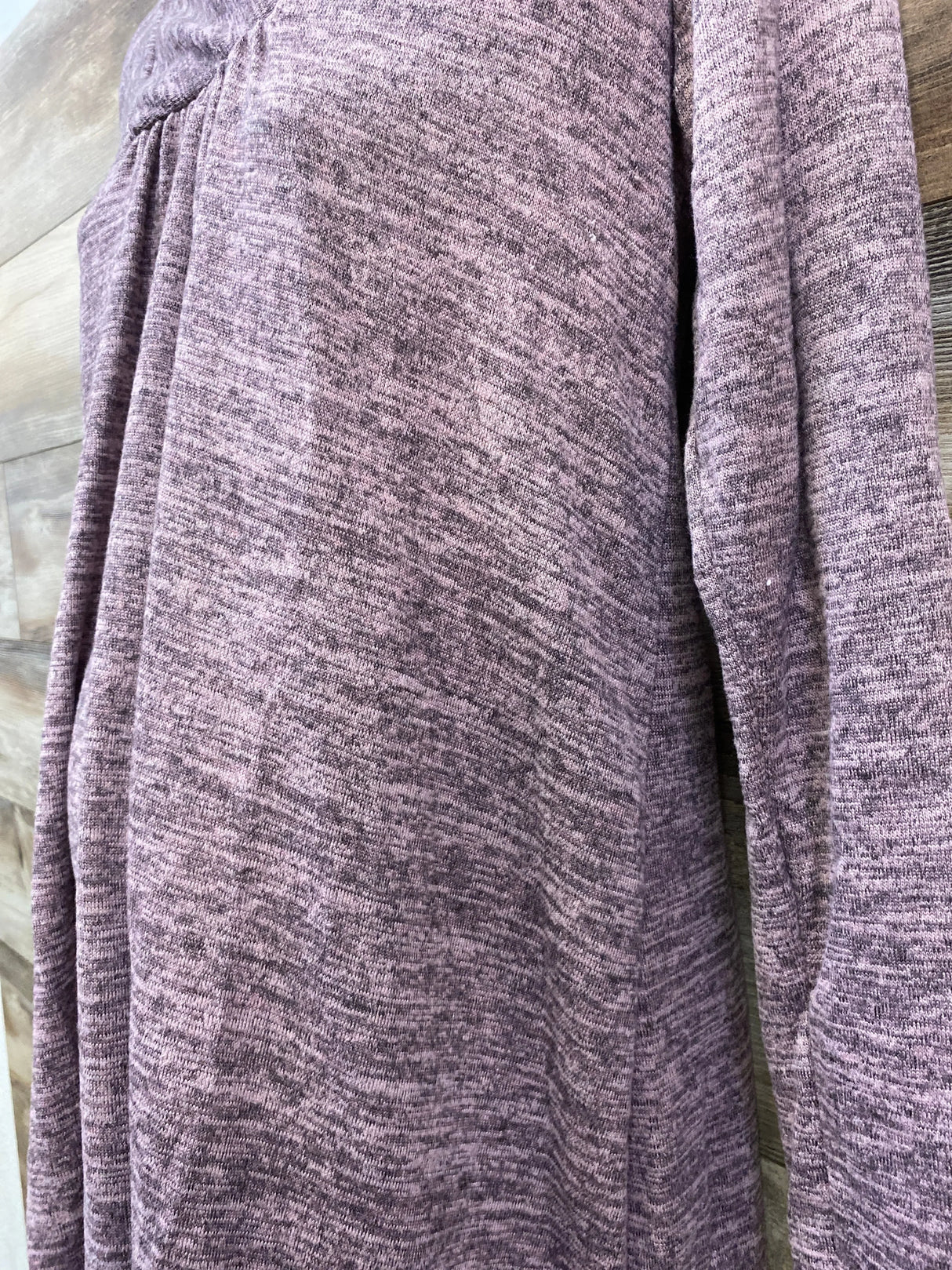 Close-up of Hello MIZ mauve shawl-collar maternity knit tunic showing gathered seam and heathered texture on wood background