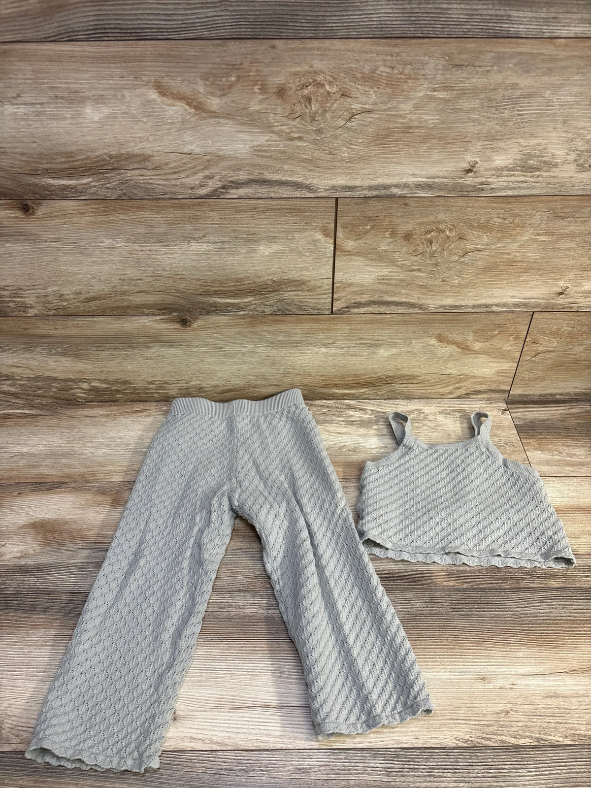Top-down view of Rylee + Cru grey pointelle knit tank top and wide-leg pants set with scalloped edges on wood floor