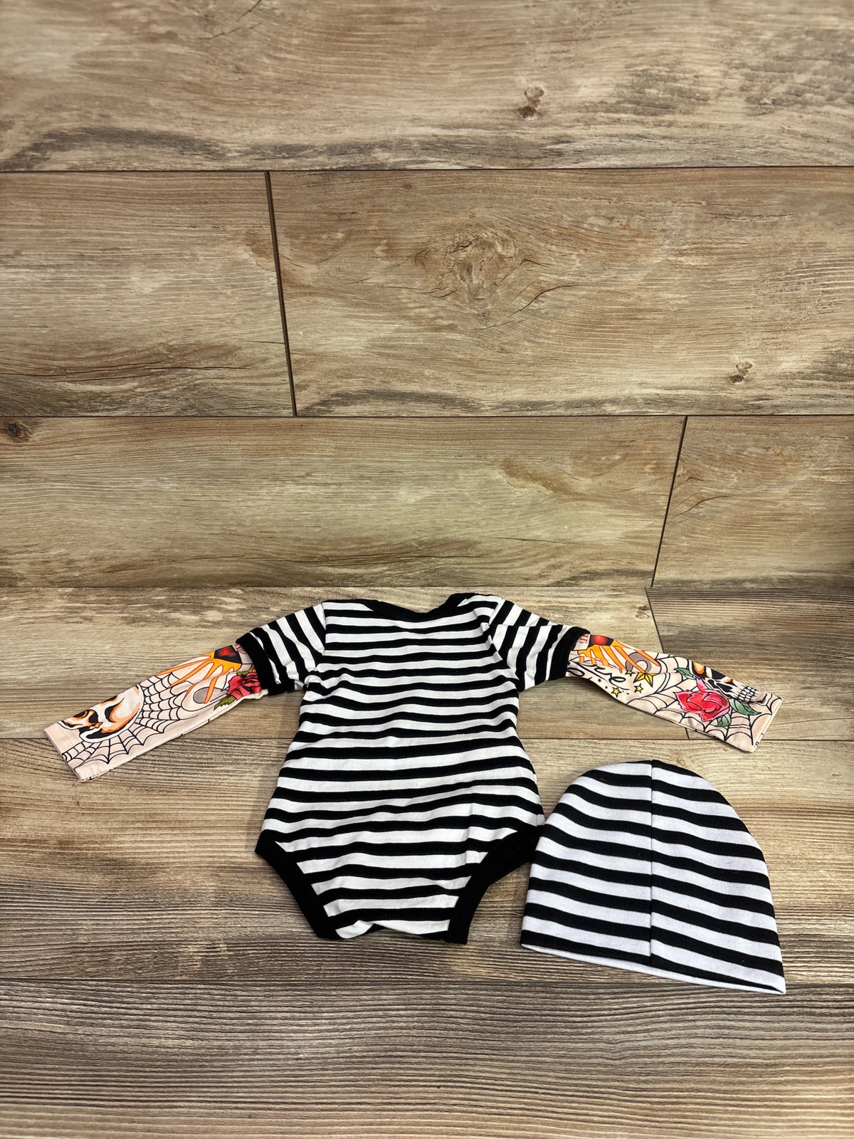 Black and white striped baby bodysuit and hat set with tattoo sleeve prints
