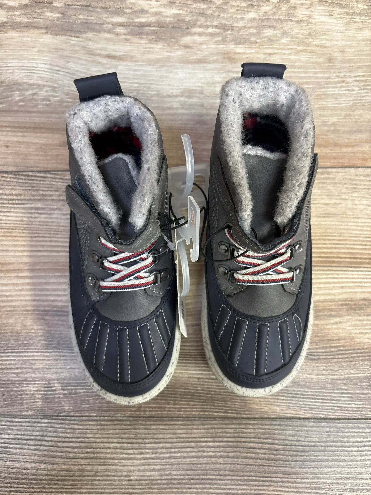 Top view of Cat & Jack Greyson toddler boots showcasing gray wool lining, red-and-white striped laces, stitched toe detail and speckled sole on wooden floor