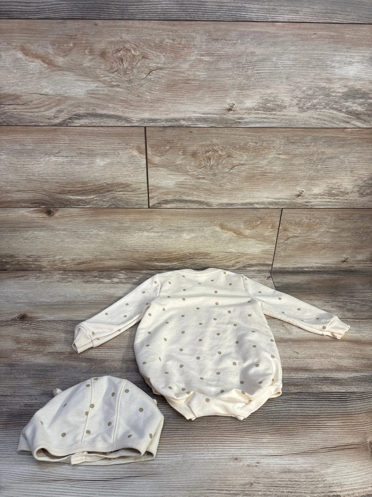 Top view of Cat & Jack 18-month bubble romper and matching hat set showcasing ivory polka dots on wood grain