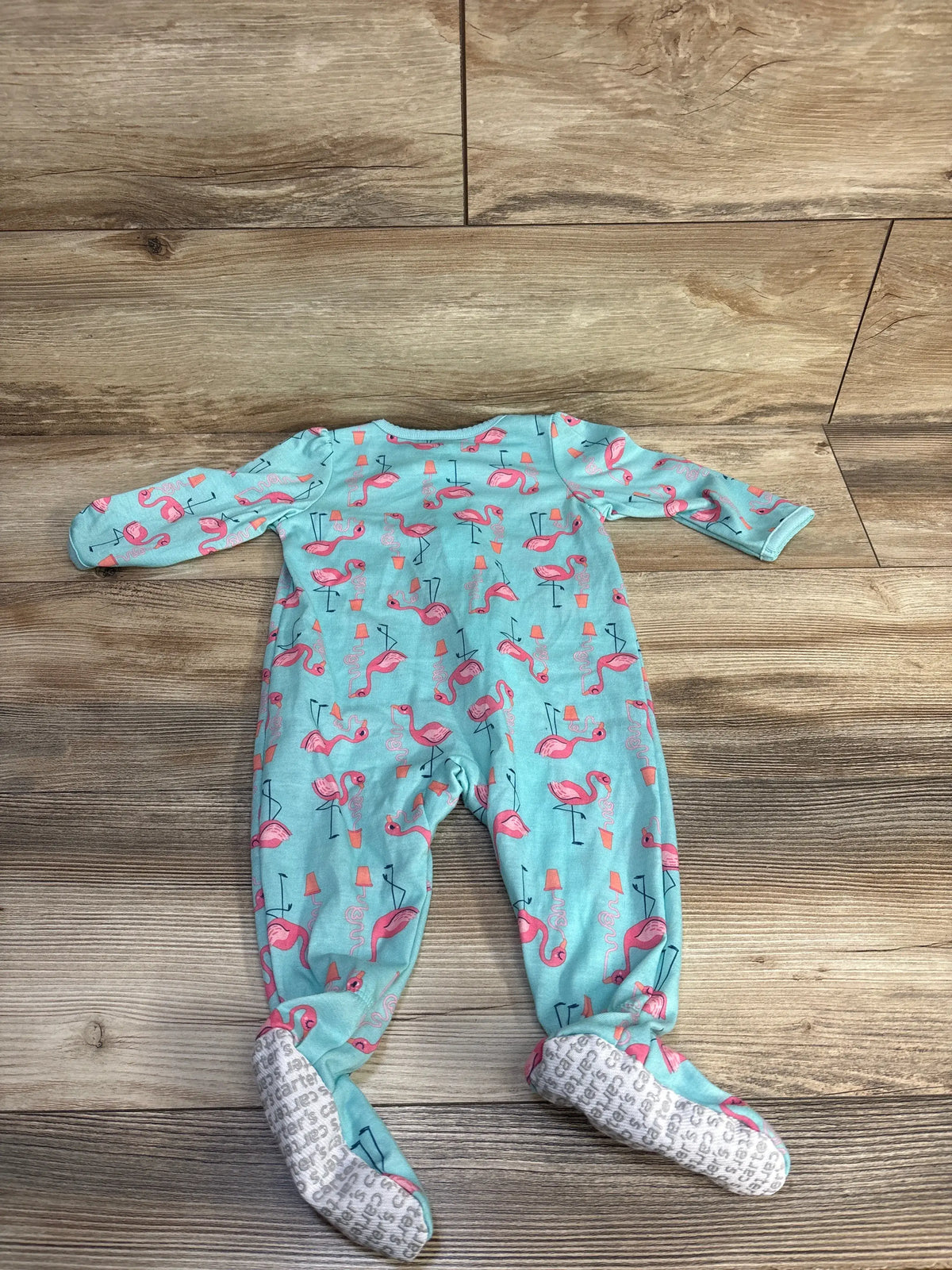 Front view of the Simple Joys blue flamingo print sleeper for 6 to 9 months, showcasing covered feet on wood flooring