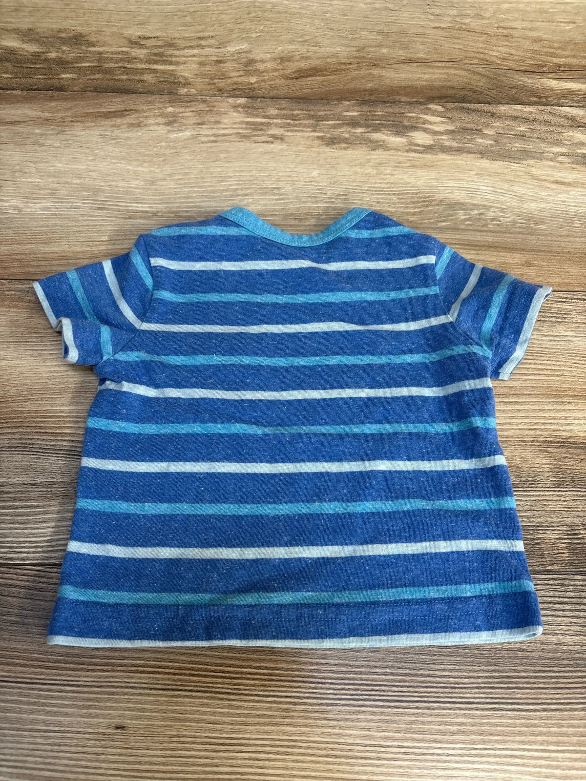 Blue striped short sleeve toddler t-shirt on wood background