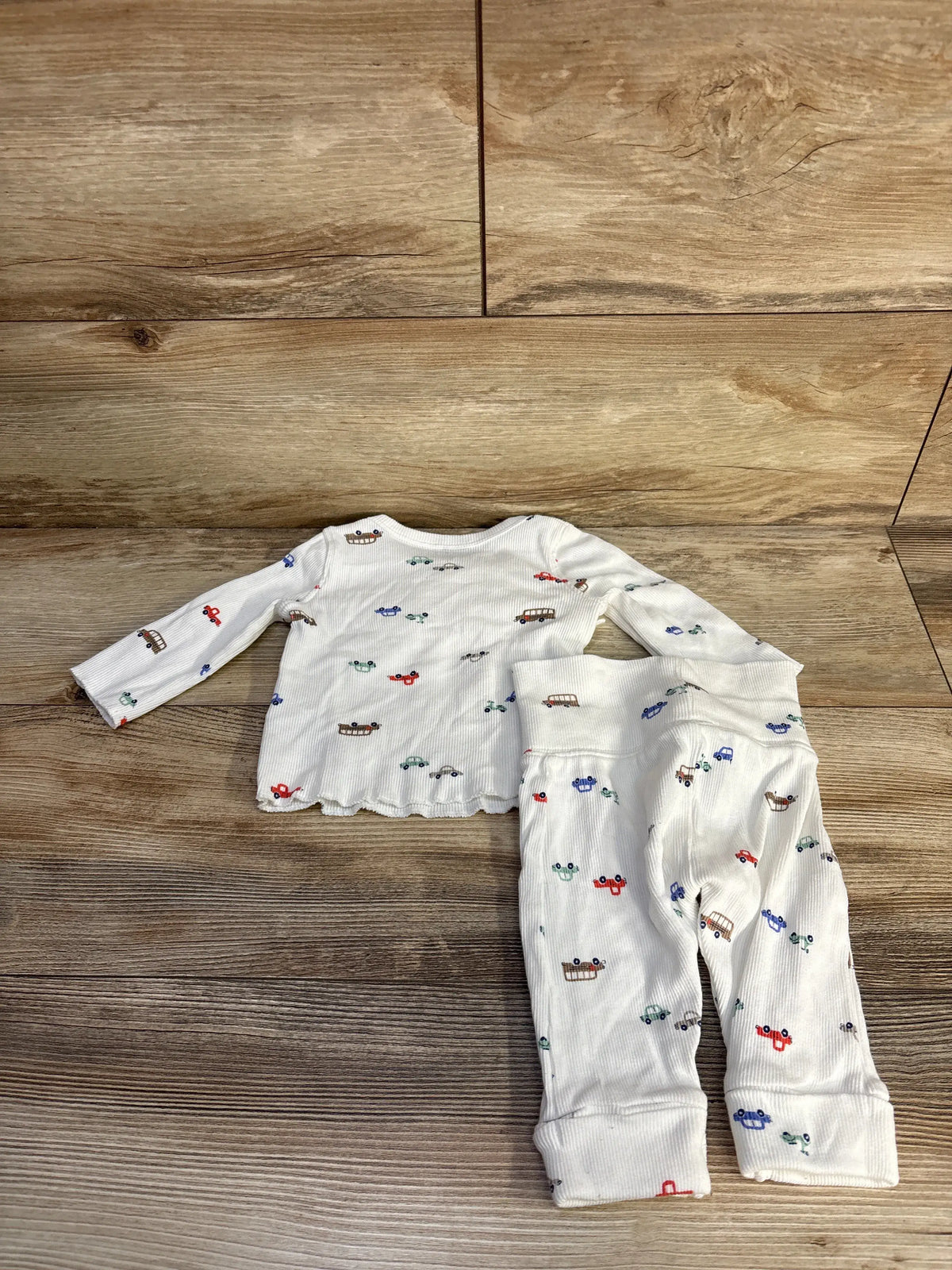 Top-down view of white Just One You 2-piece ribbed kimono set showcasing colorful vehicle print with wood floor background