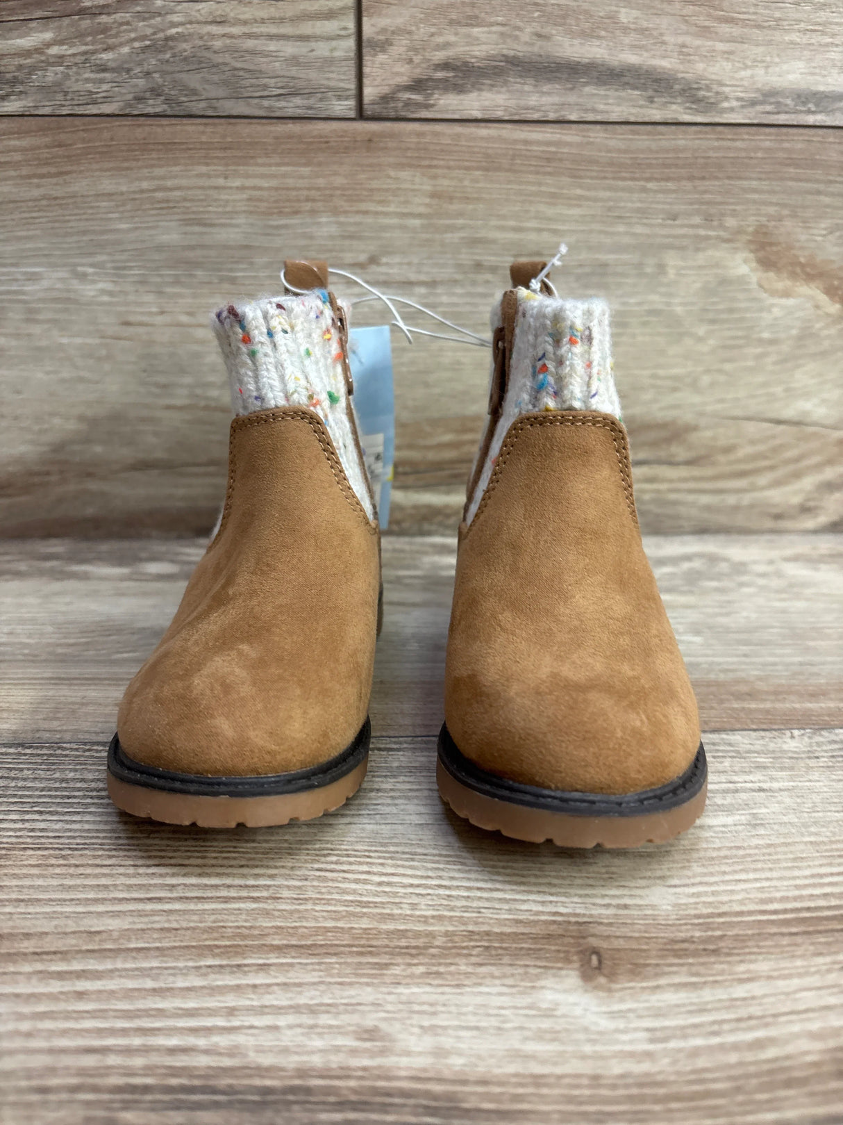 Kids brown suede ankle boots with speckled knit cuffs on wood background