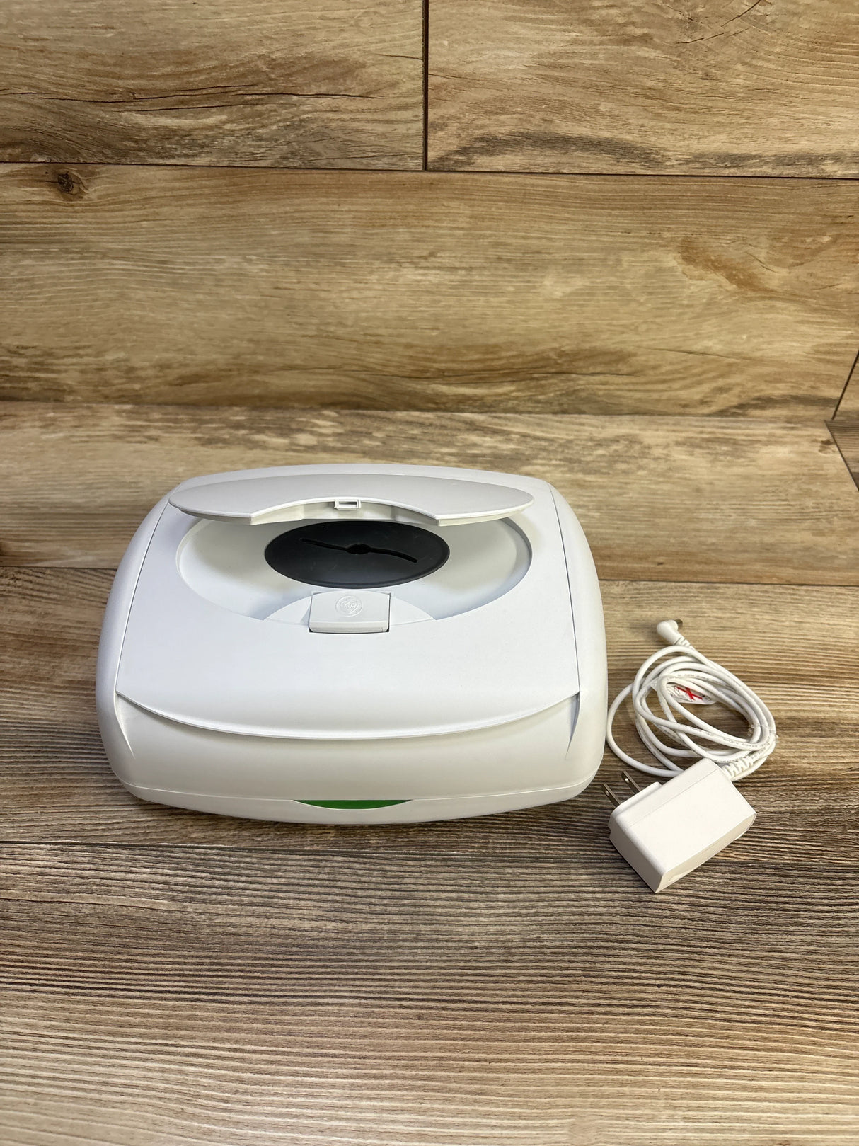 Angled top view of Prince Lionheart Ultimate Wipes Warmer showing open lid and included power adapter on wooden surface