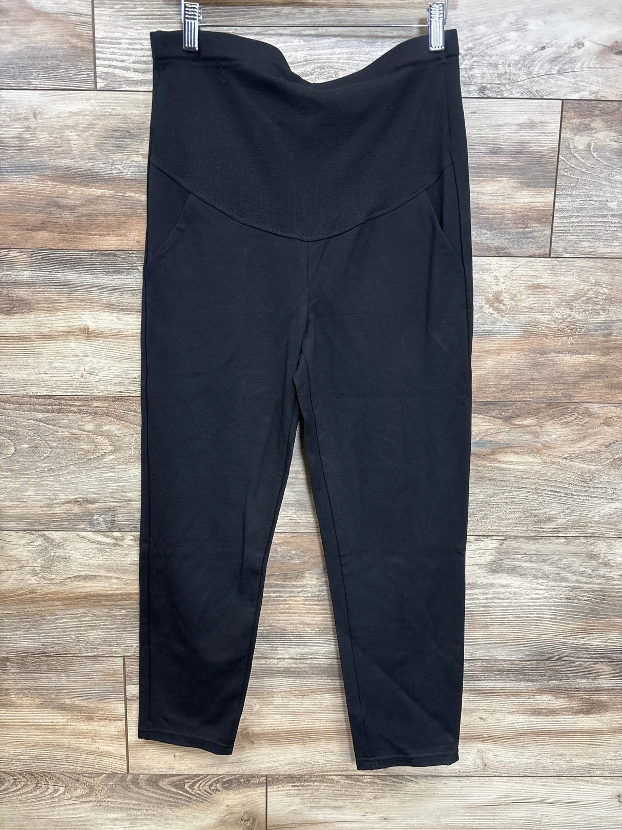 Front view of Alina Mae maternity ankle pant showcasing high-rise foldover band and tapered ankles on wood-plank floor