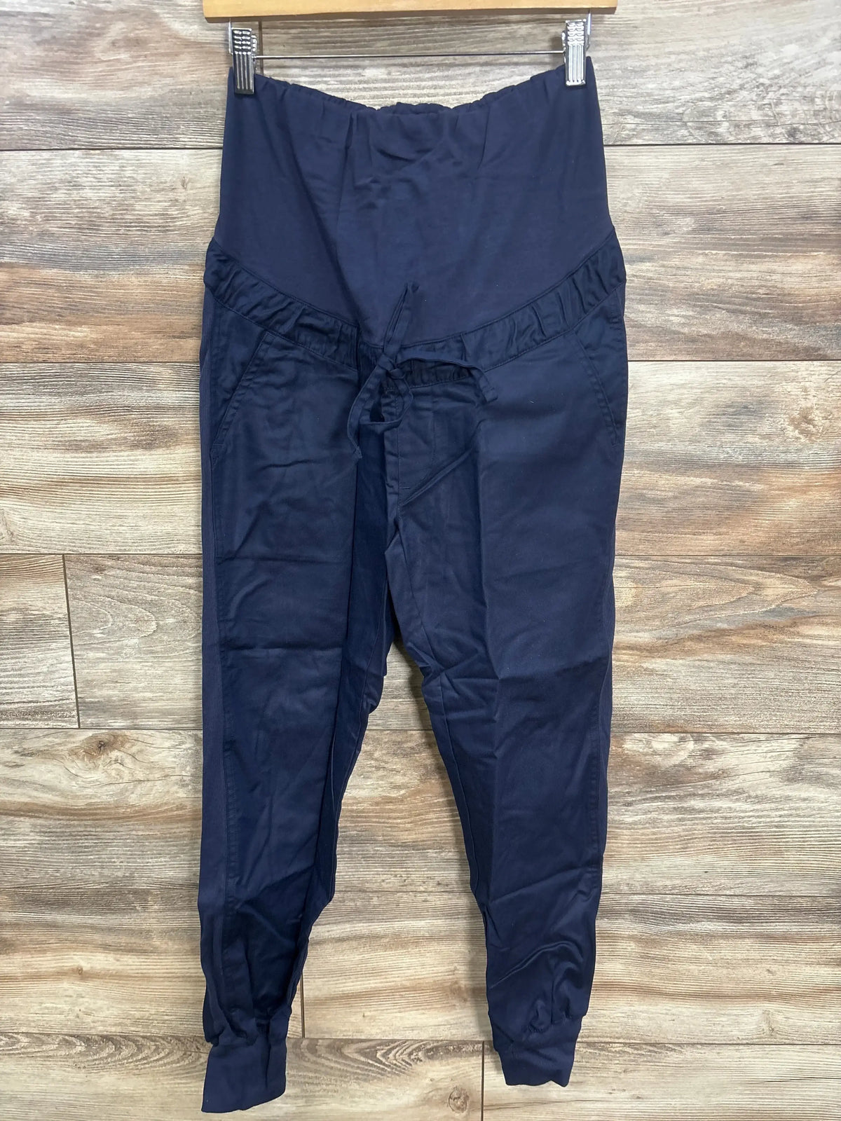 Navy blue maternity pants with elastic waistband and drawstring, displayed on wood background