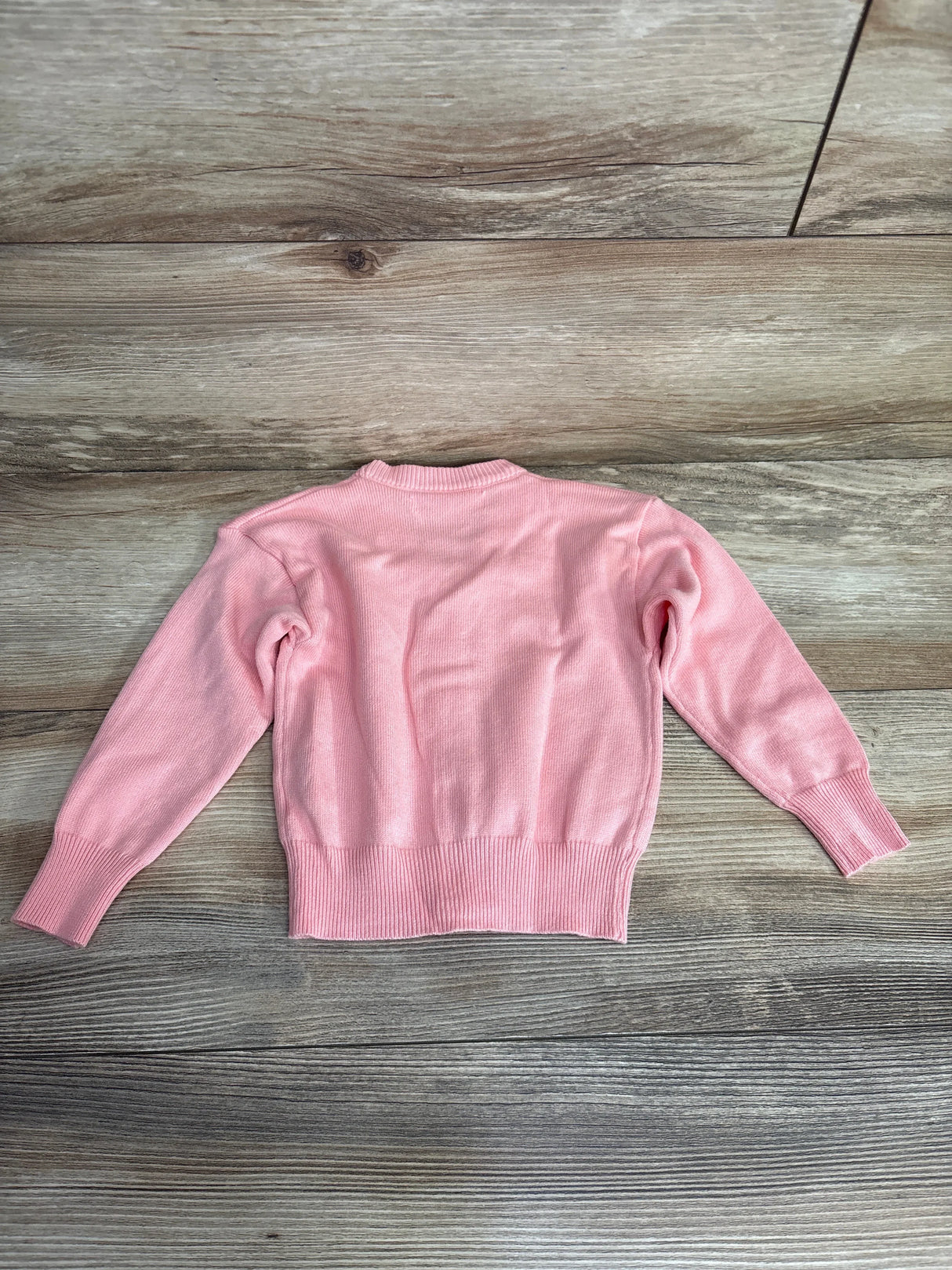 Back view of pink Shein button-front cardigan (2T) showing long sleeves and ribbed hem on wood background