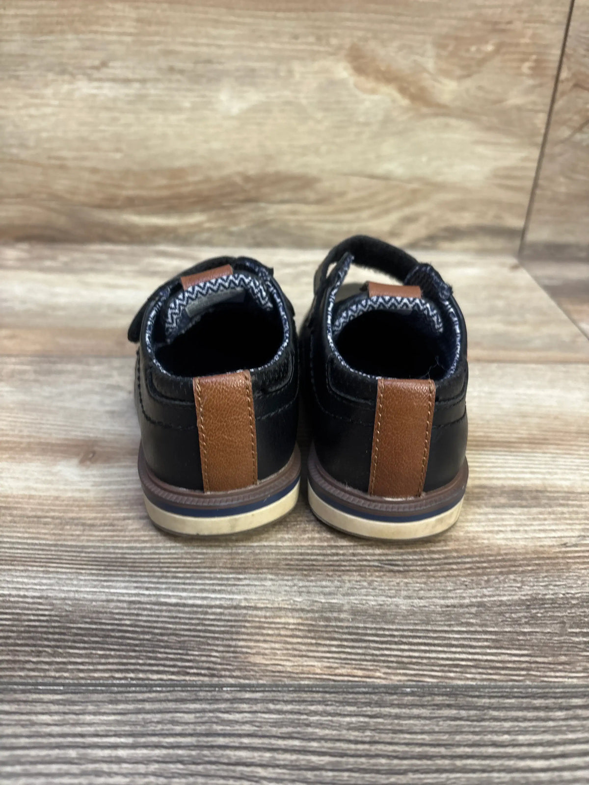 Rear view of NWOT Nordstrom Rack Dustin Oxford dress shoes in black, showcasing brown heel tabs and contrasting soles on a wood floor