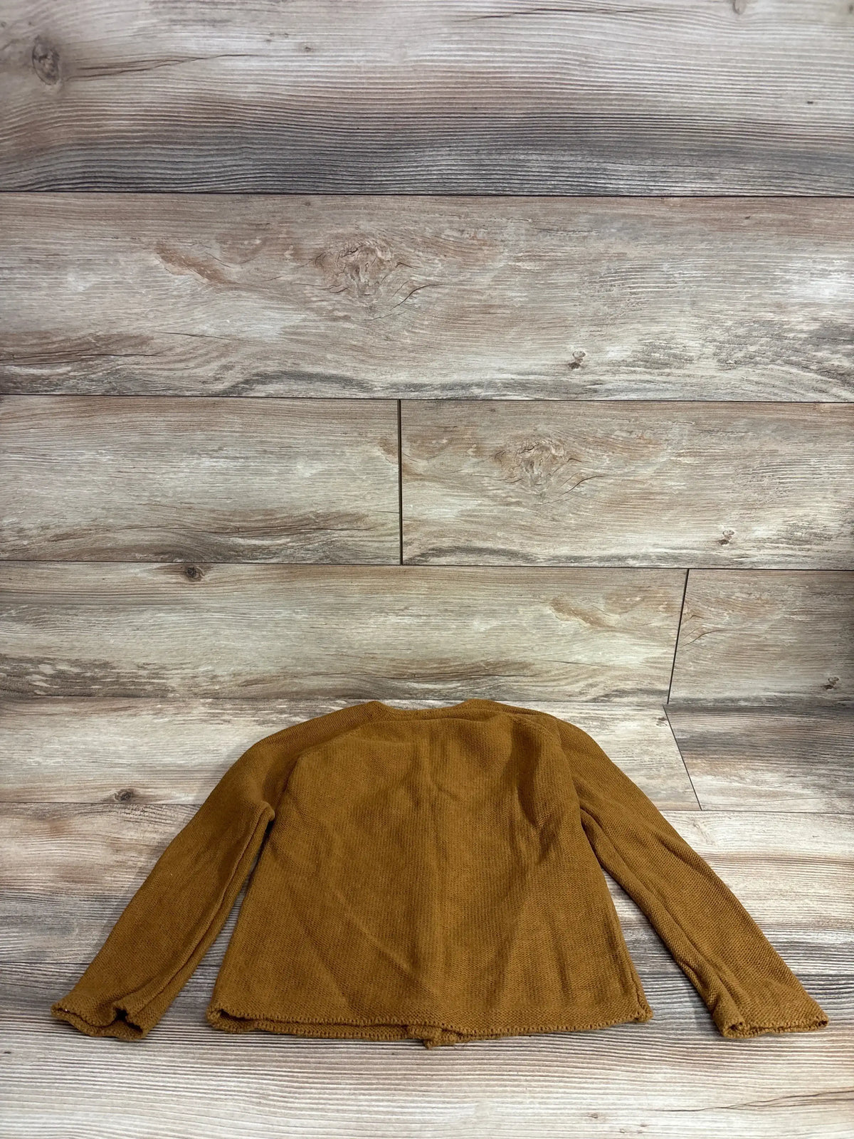 Back flat lay of Jamie Kay Organic Simple Cardigan in caramel, size 5T showing ribbed texture and lettuce-edge hems on wood floor