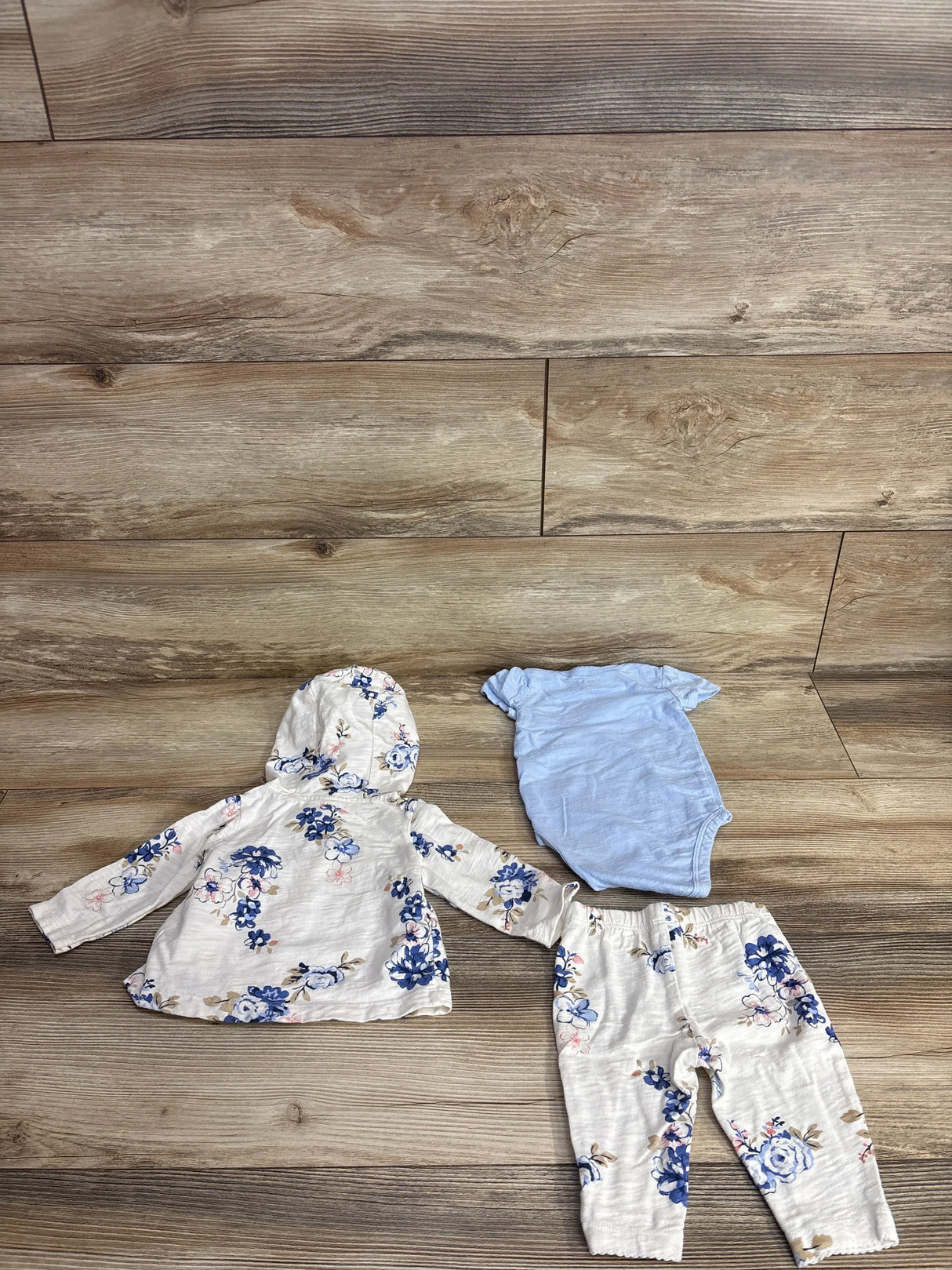 Baby girl floral hoodie set with pants and blue bodysuit on wood floor
