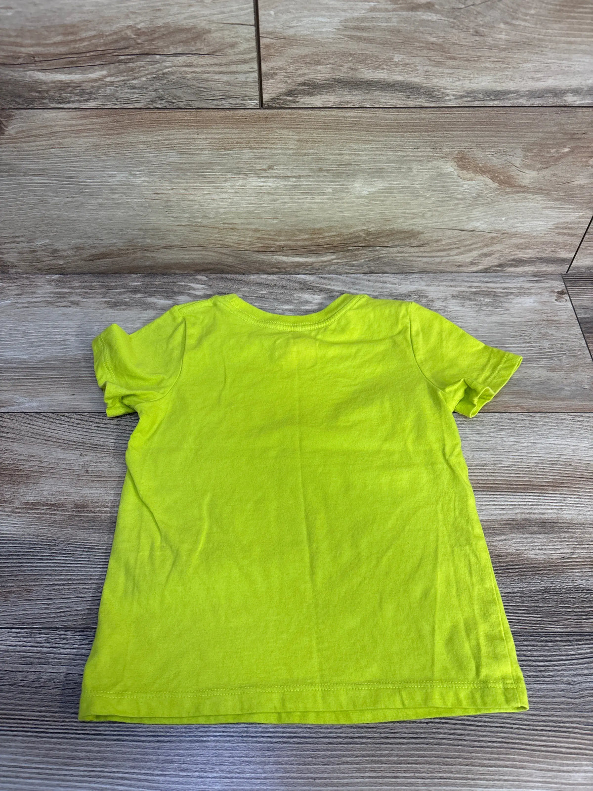 Back view of Cat & Jack toddler shirt showcasing lime green short sleeves and relaxed fit on a wood-look background