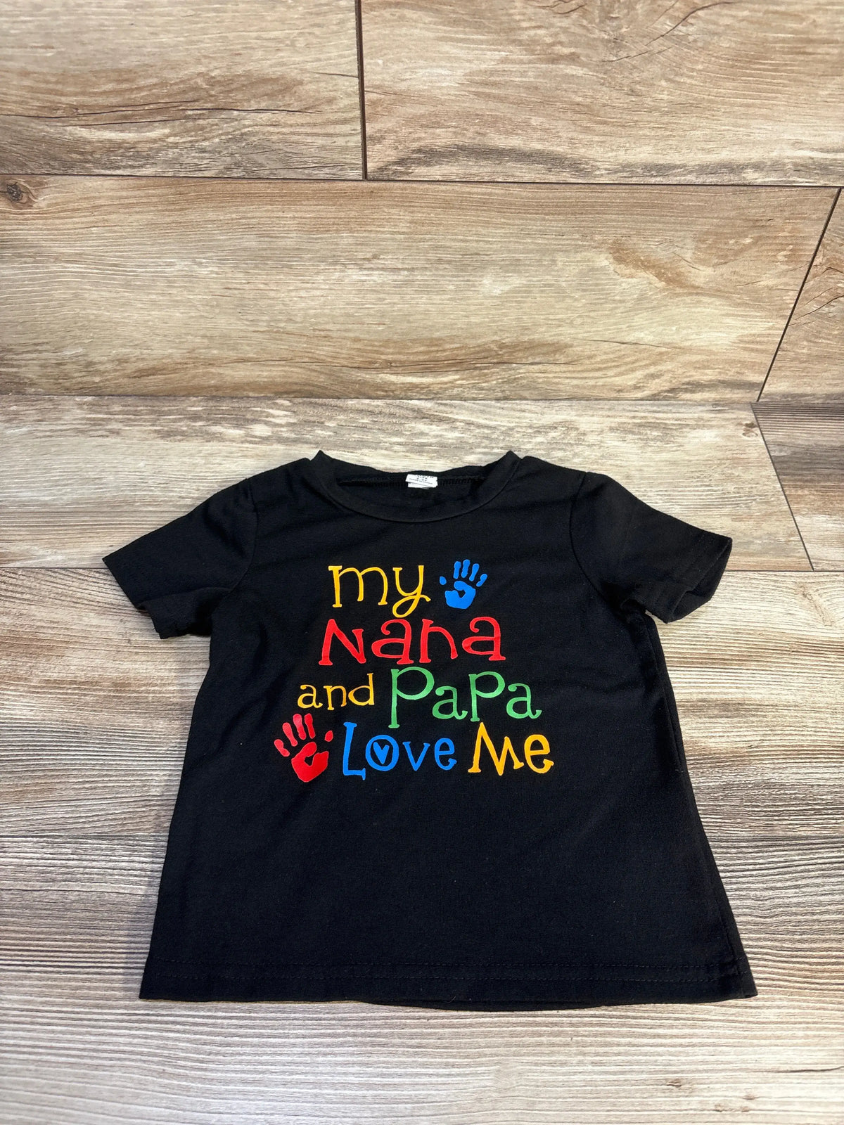 Front view of a black toddler graphic shirt showcasing colorful My Nana and Papa Love Me text and handprints
