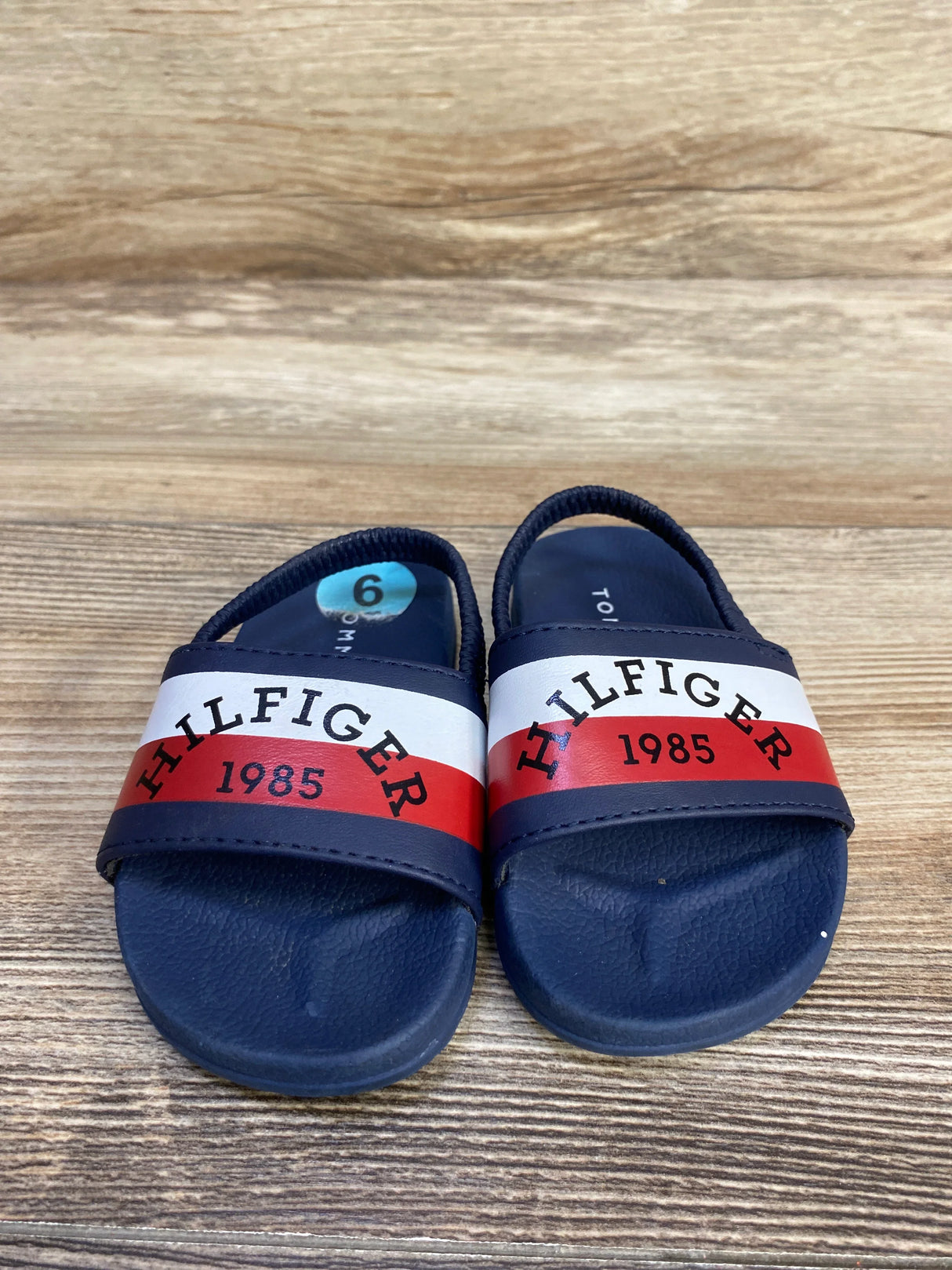 Kids blue Hilfiger 1985 sandals size 6 on wood background
