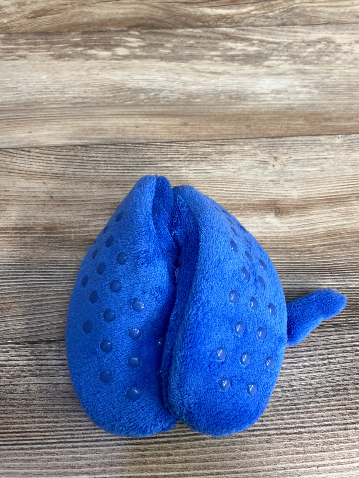 Blue plush cat toy with textured dots on a wooden surface
