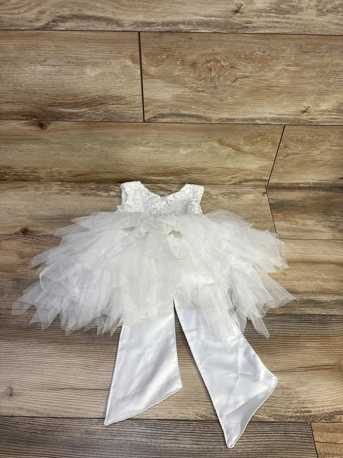 Front view of Topmaker backless A-line flower girl dress with white lace bodice, flower detail, and layered tulle tutu
