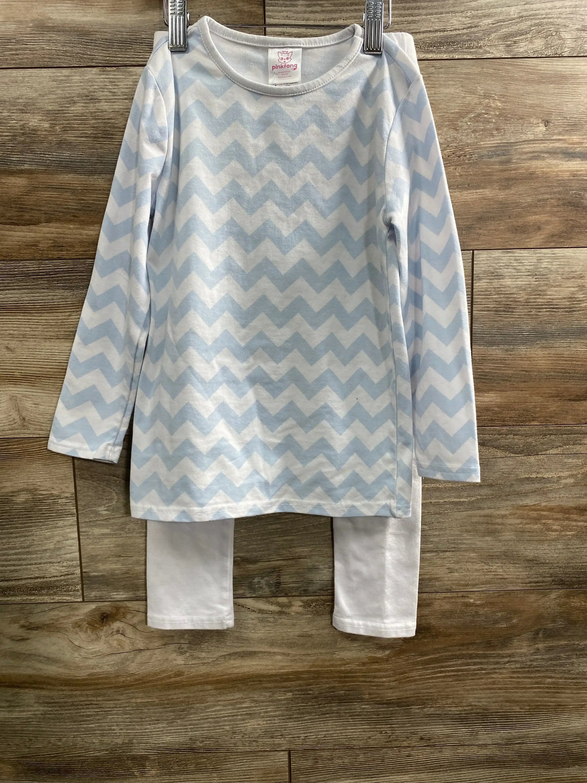 Front view of a blue and white zigzag two-piece set with long sleeves and matching pants on a wooden floor
