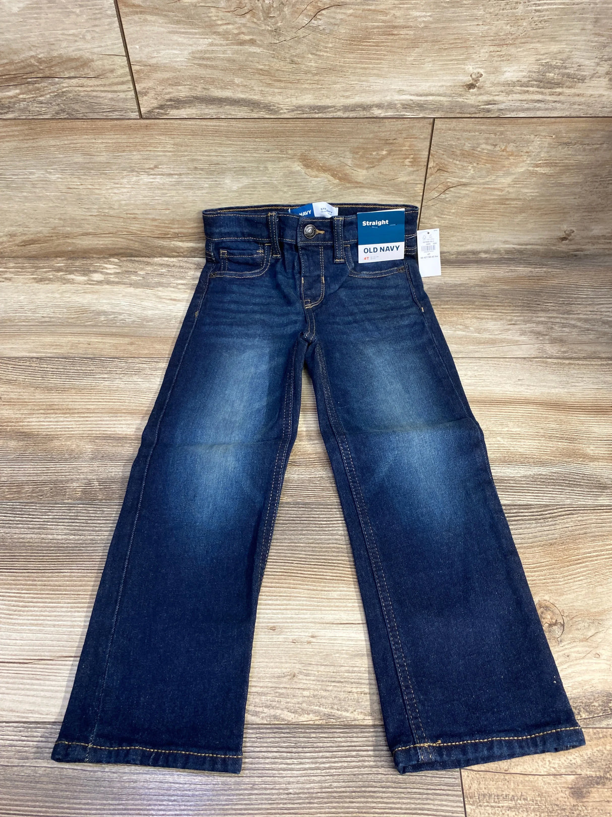 Kids dark wash straight leg jeans with tags, displayed on wood background
