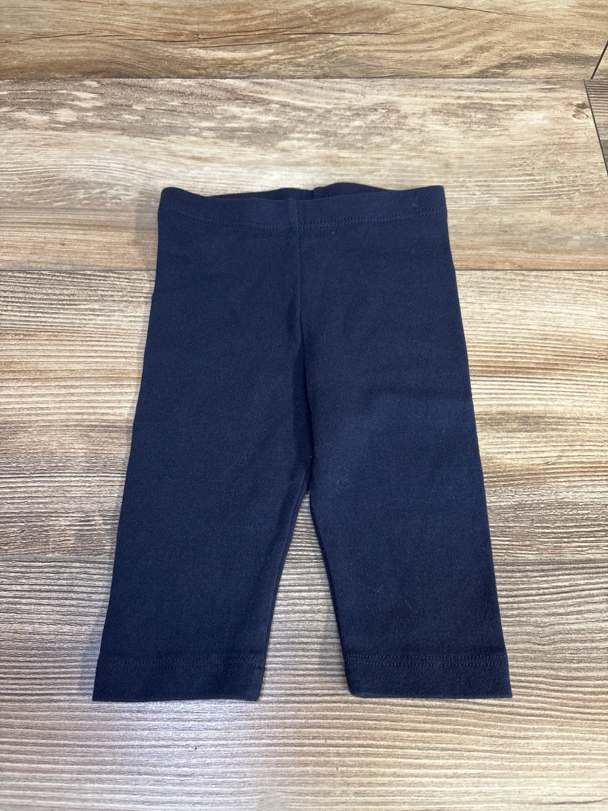 Front view of City Threads long bike shorts showcasing navy color and long length with a wood-grain background