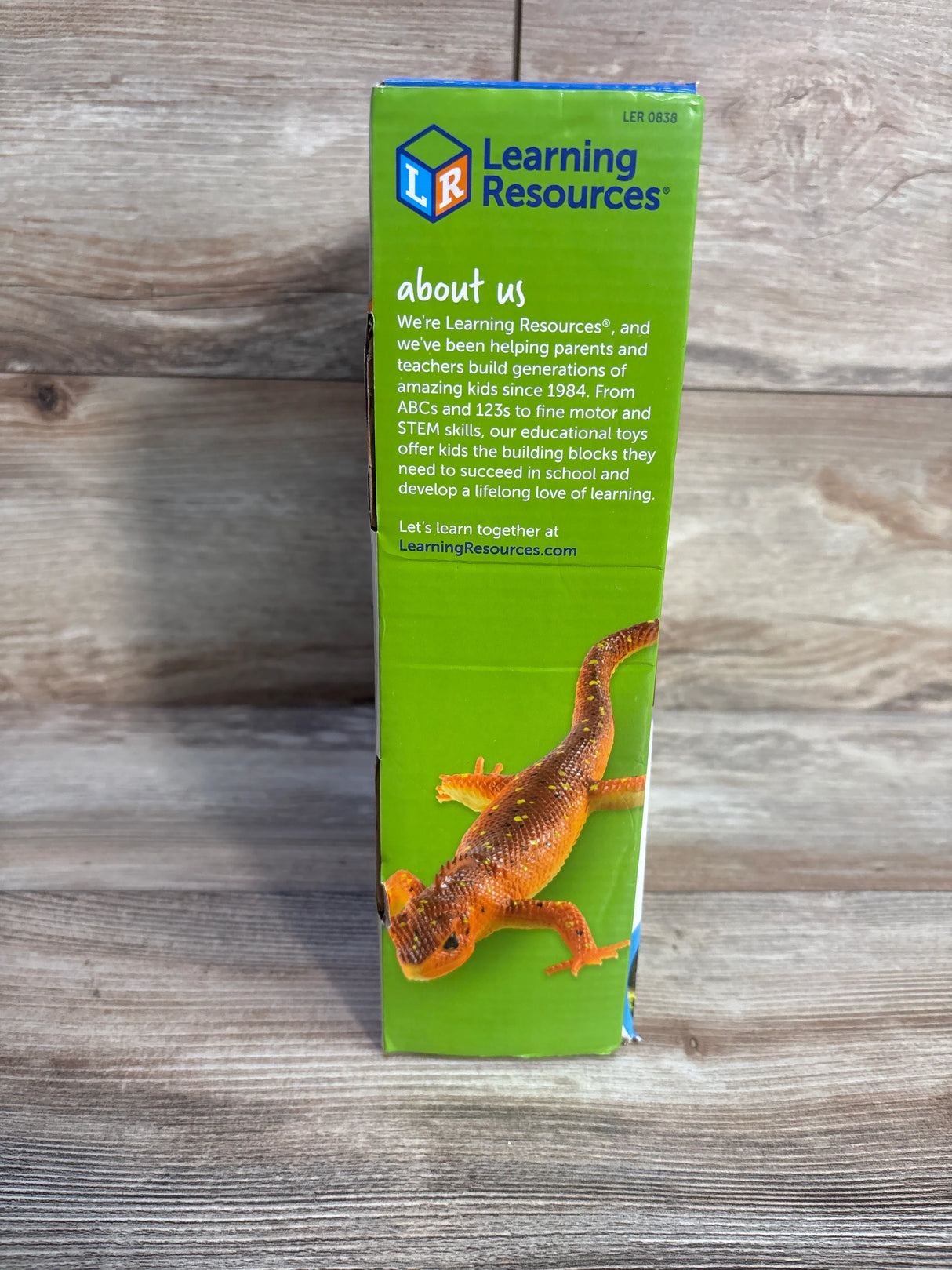 Learning Resources educational toy box side with orange lizard image and company about us text