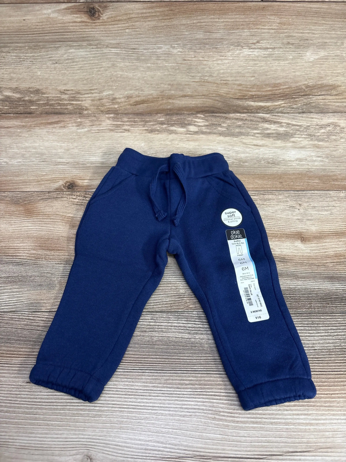 Navy blue baby jogger pants size 6 months with drawstring and soft fabric on wooden surface