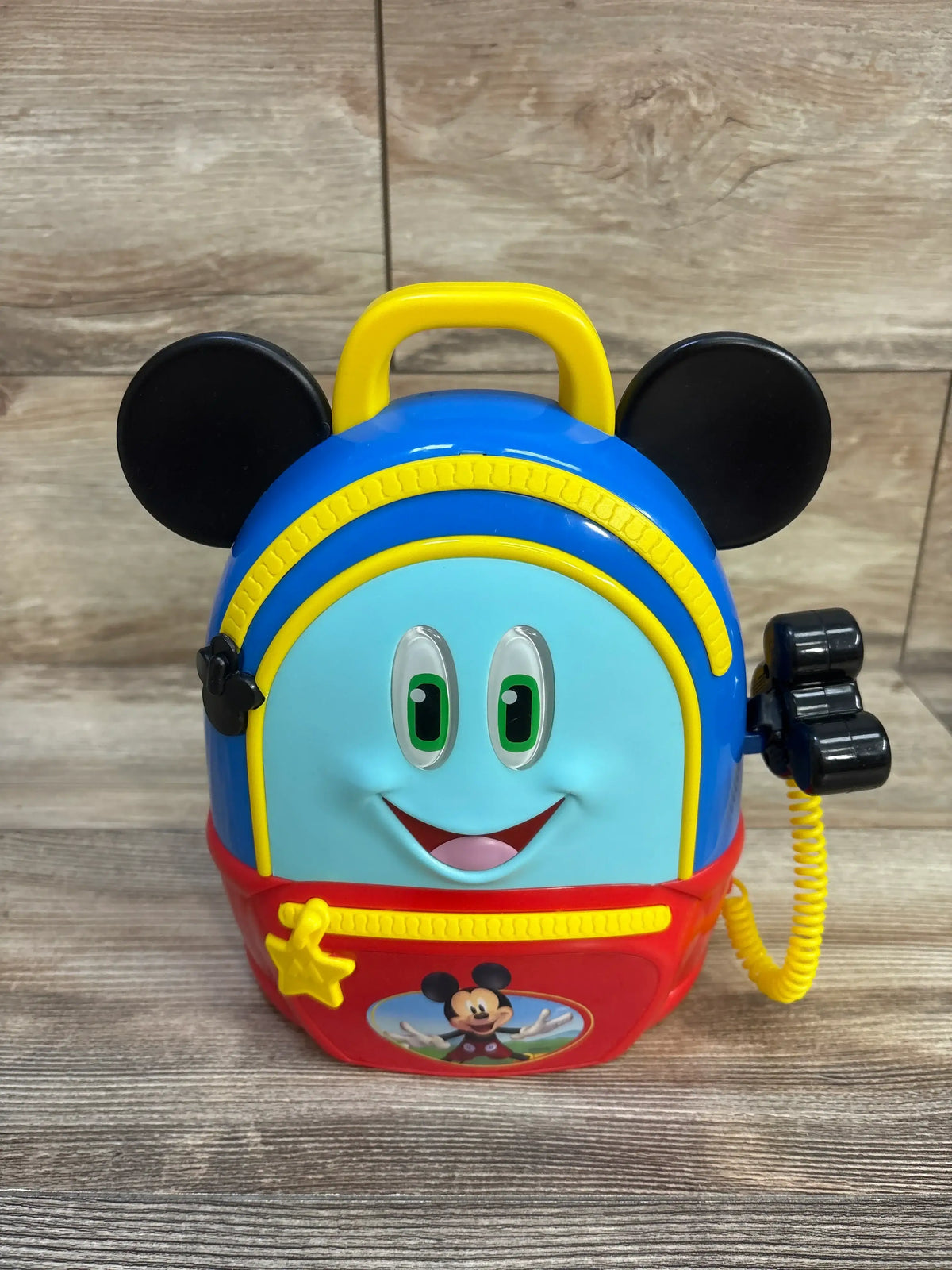 Front view of Just Play Disney Mickey Mouse Funhouse Adventures Backpack Playset showcasing colorful Mickey Mouse design, yellow handle, and communicator