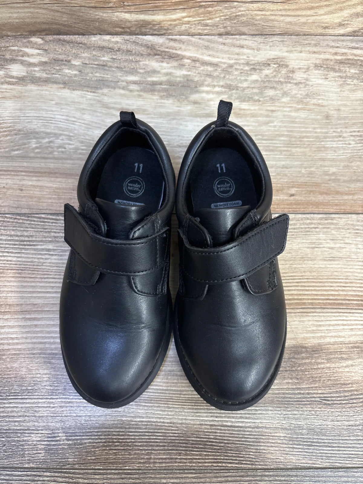 Pair of black Me n Mommy To Be oxford dress shoes for kids, size 11C, on a wooden surface.