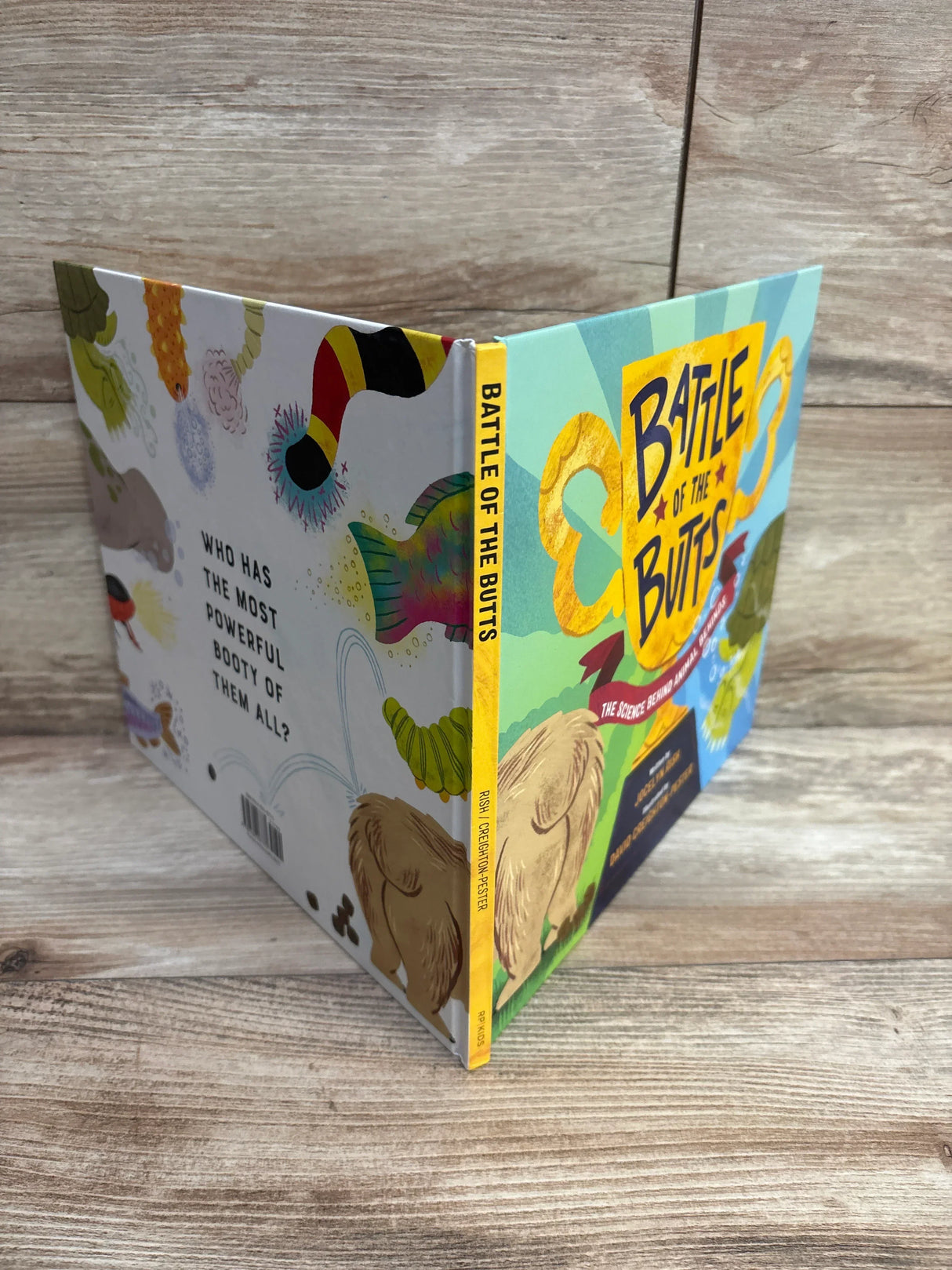 Battle of the Butts children's book illustrated cover on wood surface, colorful animal artwork