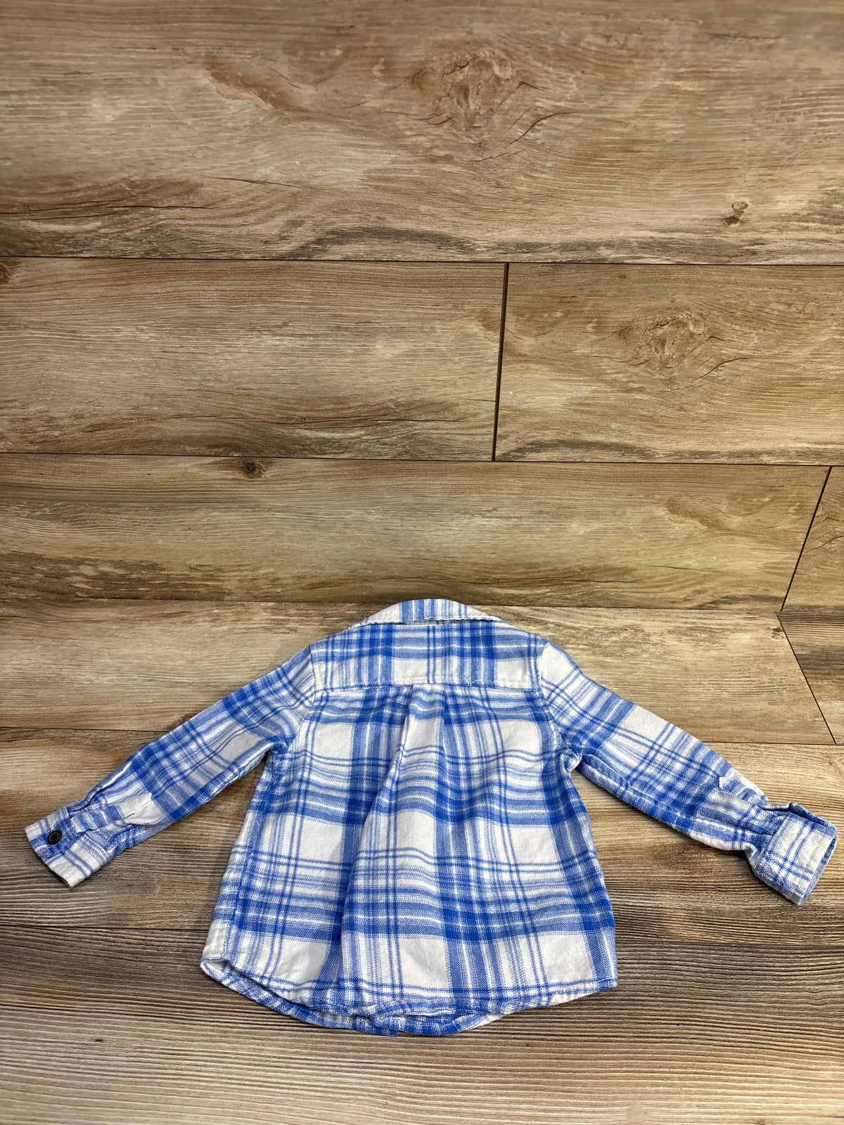 Cat & Jack blue and white plaid flannel shirt for toddlers, laid flat on a wooden background