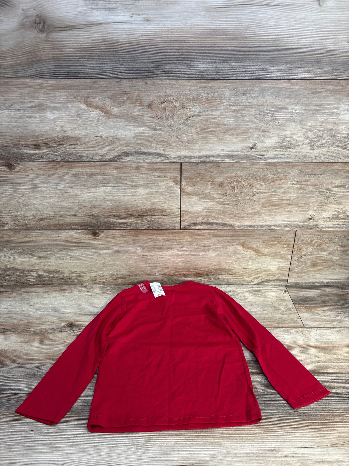 Red long sleeve kids shirt on wood floor, resale clothing for children