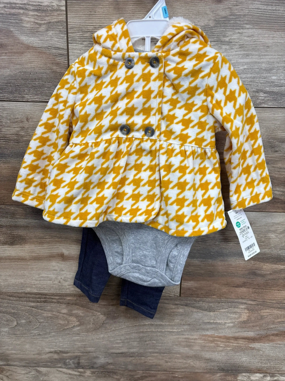 Baby outfit with yellow and white houndstooth hooded jacket, gray bodysuit, and dark blue pants on wooden floor