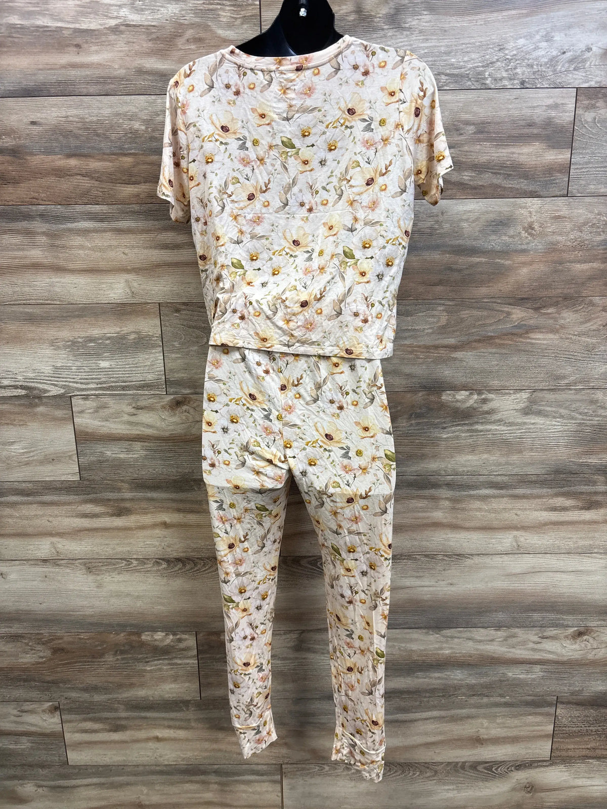 Front view of maternity bamboo pajama set in ivory floral with top and leggings on mannequin against wood wall