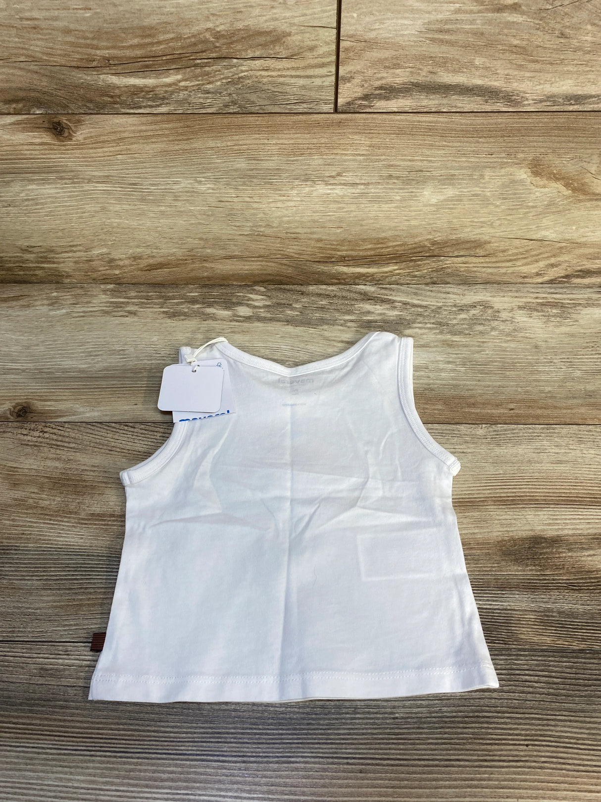 Flat lay of white Mayoral toddler tank top (9M) showing sleeveless design and attached tag on wood floor background
