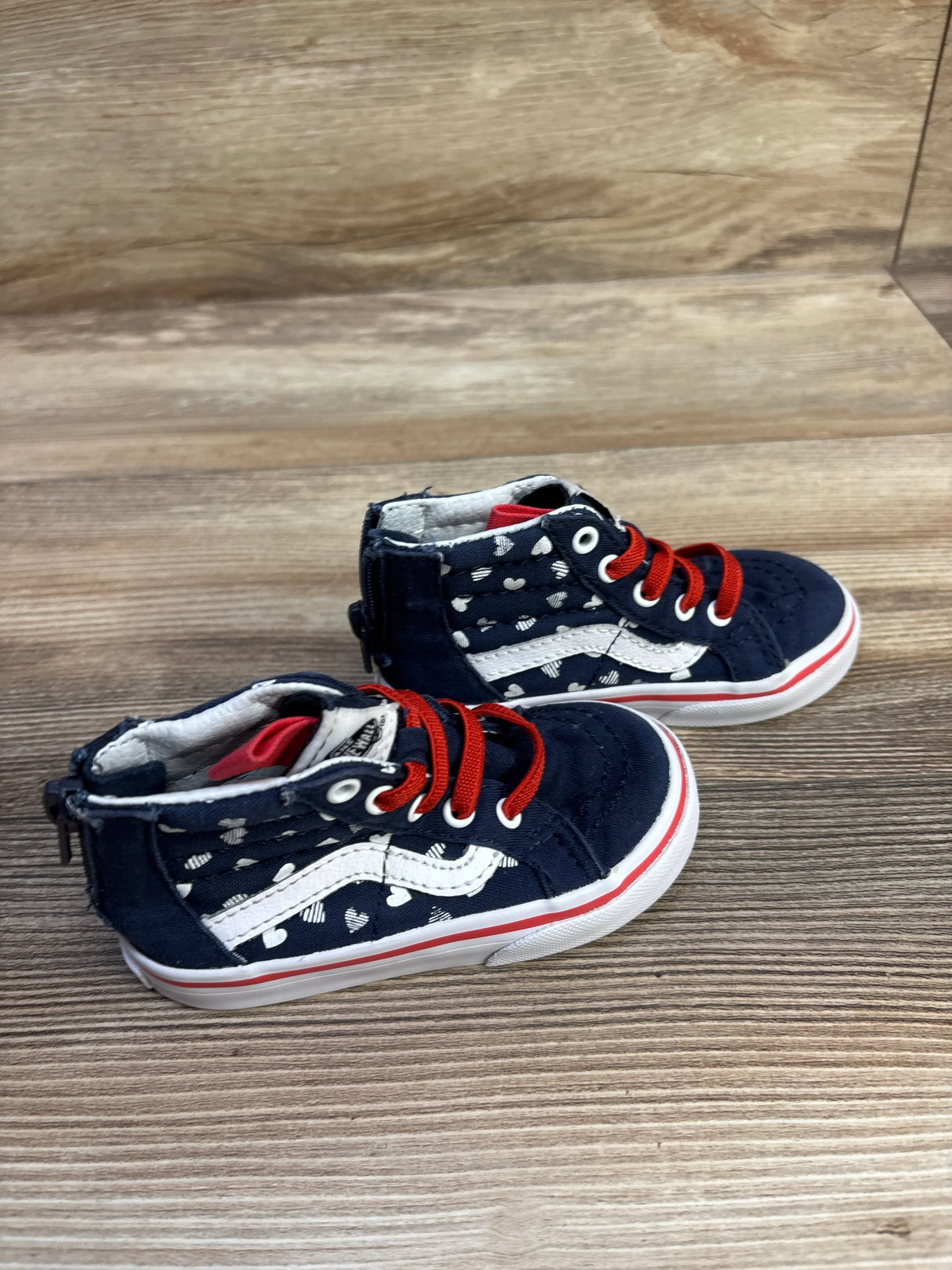 Angled view of Vans Sk8-Hi Zip size 6C showing navy with white hearts, white side stripe, red laces on wood background