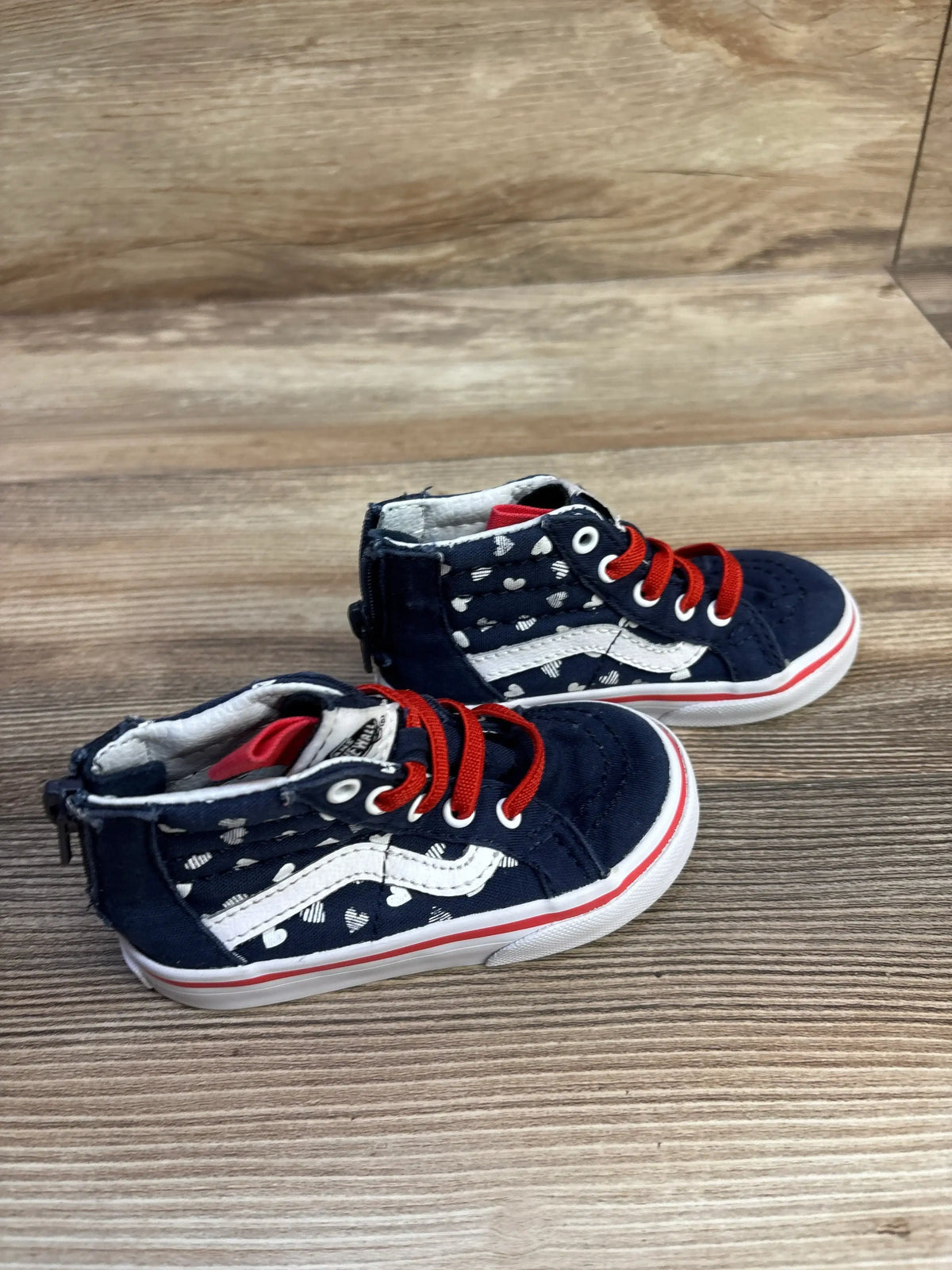 Angled view of Vans Sk8-Hi Zip size 6C showing navy with white hearts, white side stripe, red laces on wood background
