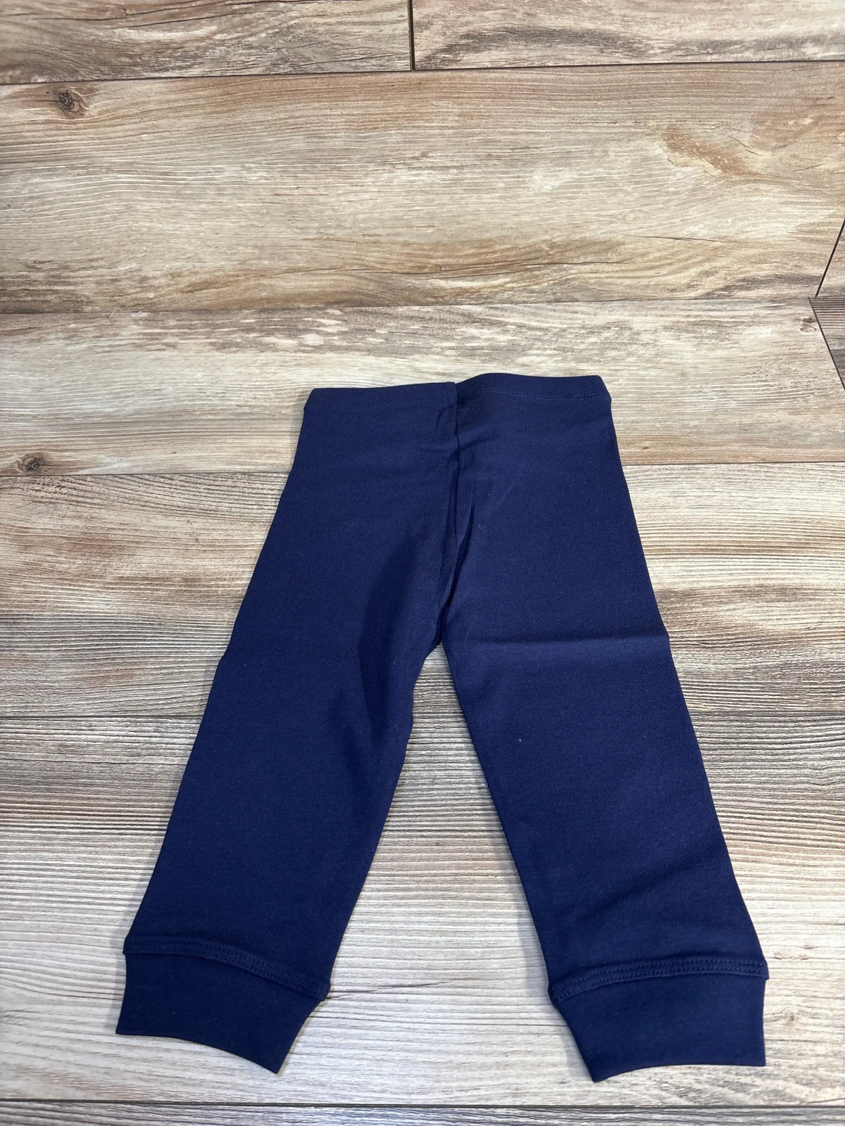 Navy blue baby leggings on wood background, soft cotton toddler pants display