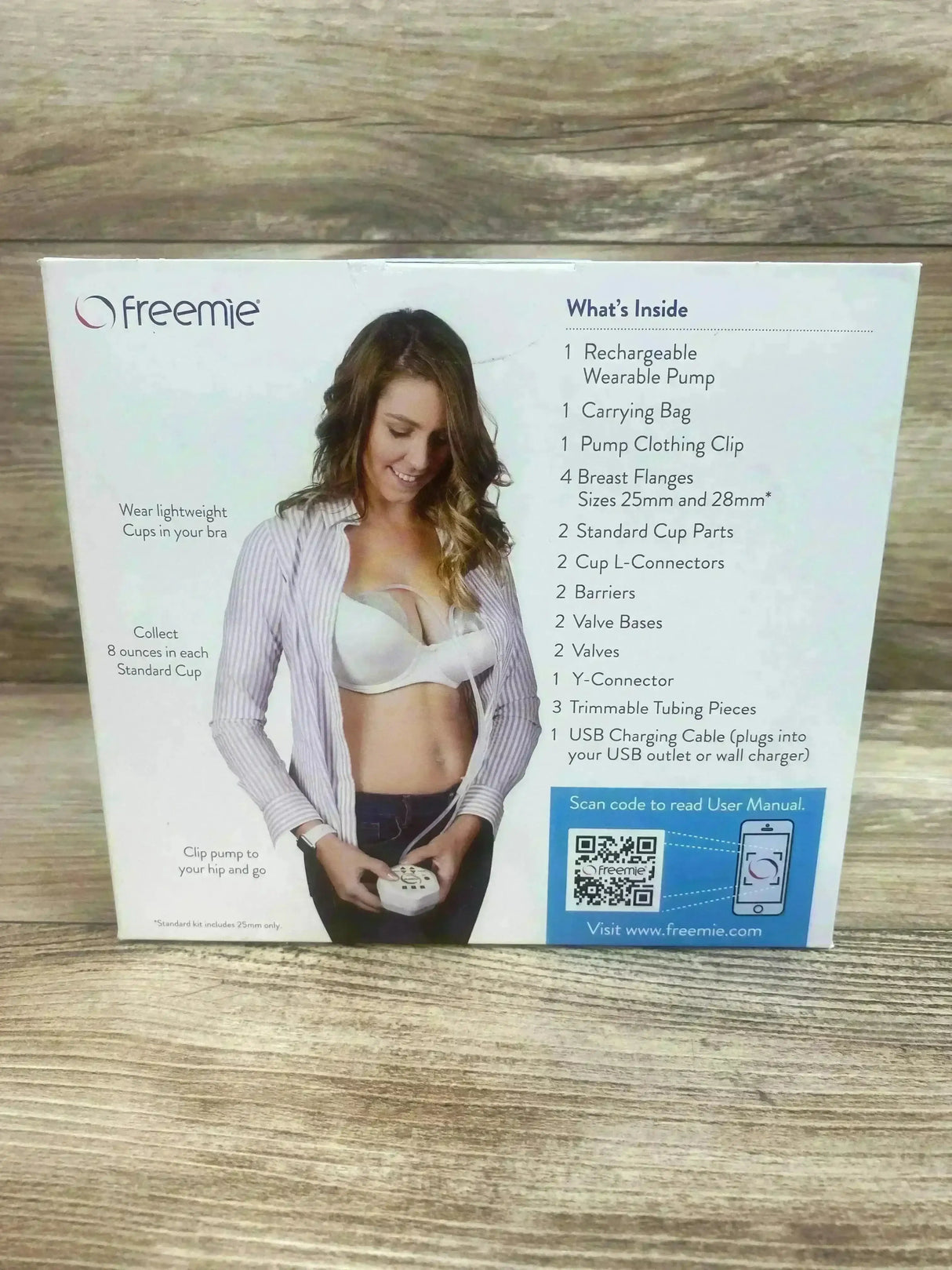 Front of Freemie Independence II box showing model wearing wearable cups in a bra, contents list and QR code on a wooden surface