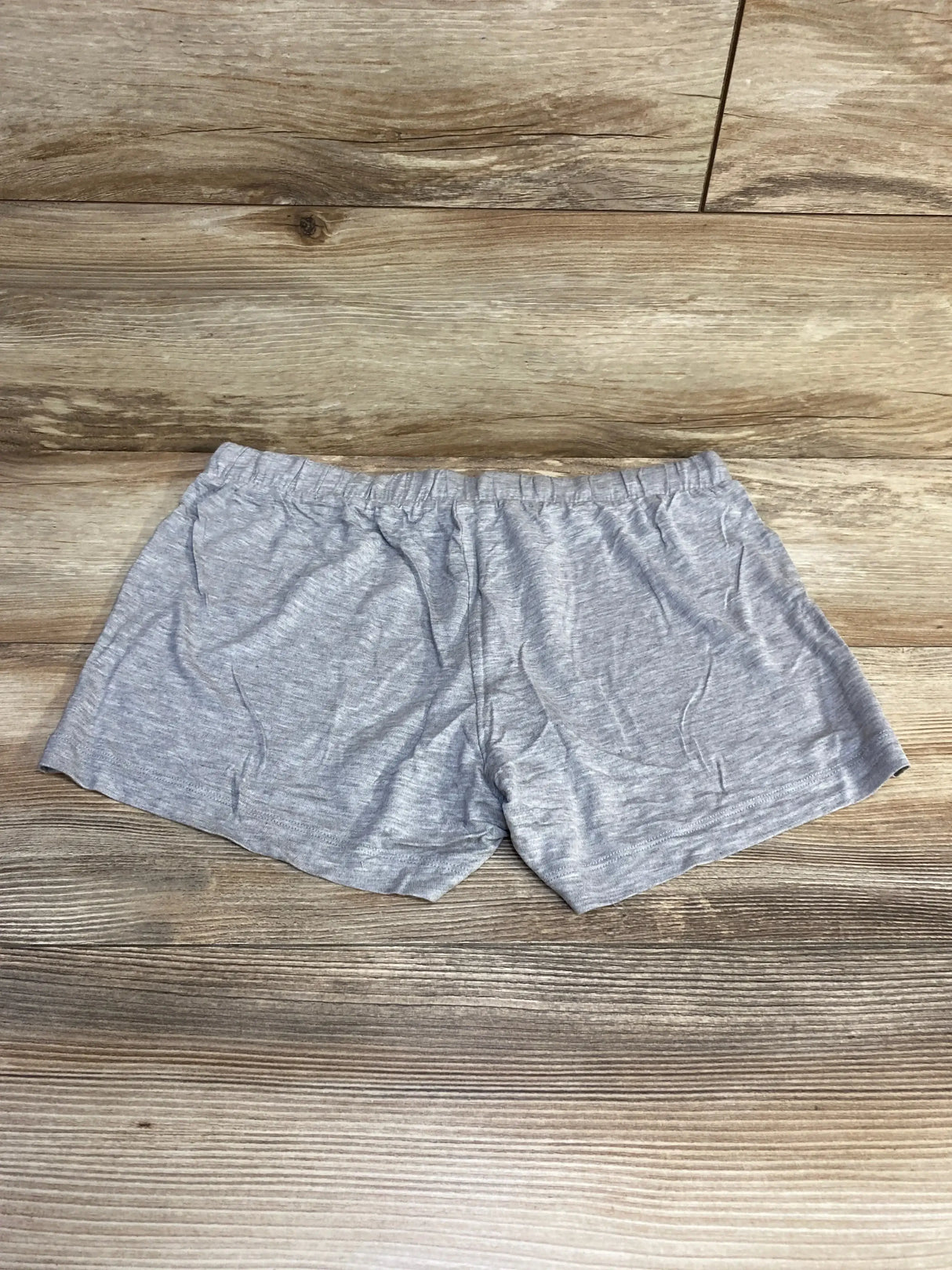Flat lay of grey Gap Body maternity modal shorts showing elastic high waistband and short inseam on wood background