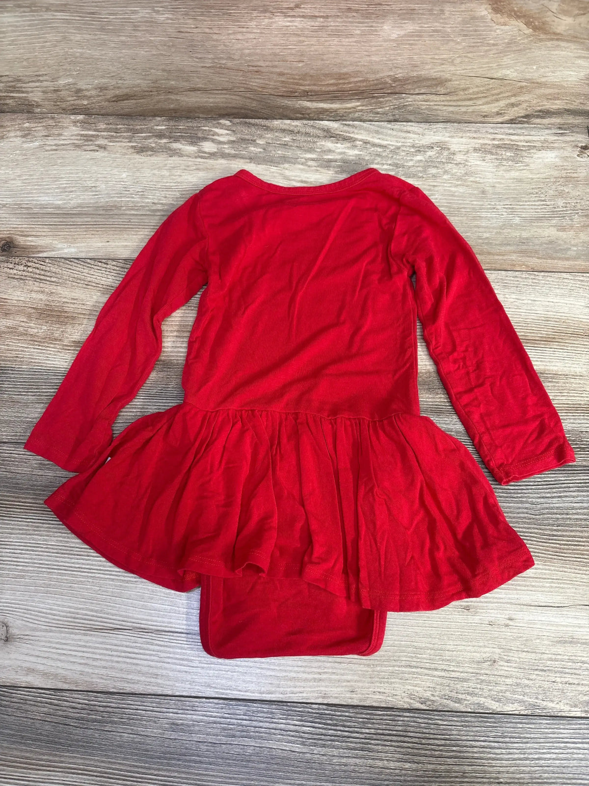 Red long-sleeve toddler dress with ruffled hem on wooden floor
