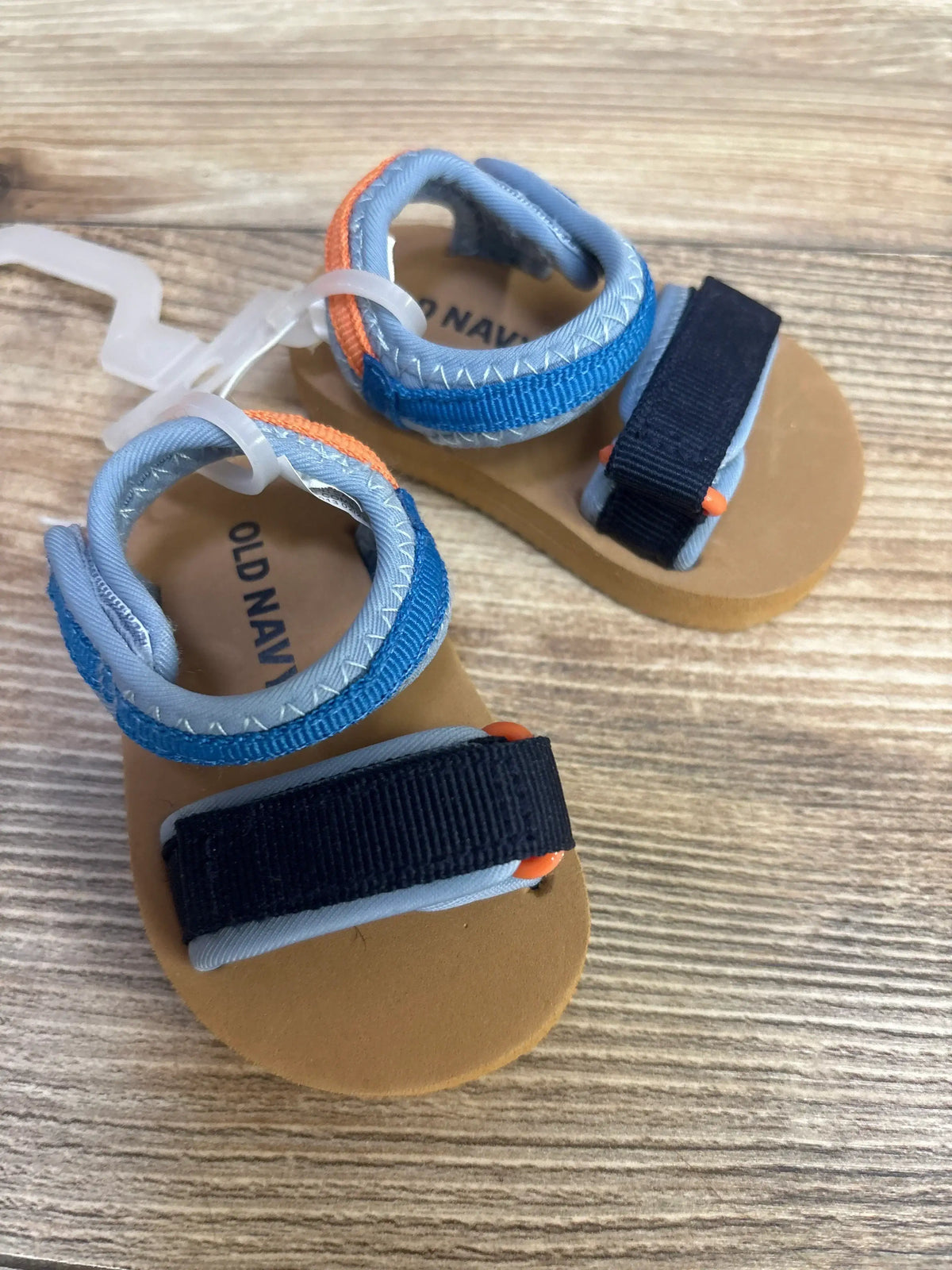 Top view of Wonder Nation Sports Slides Black sz 5c showcasing open toe and slip-on straps on a wood grain surface