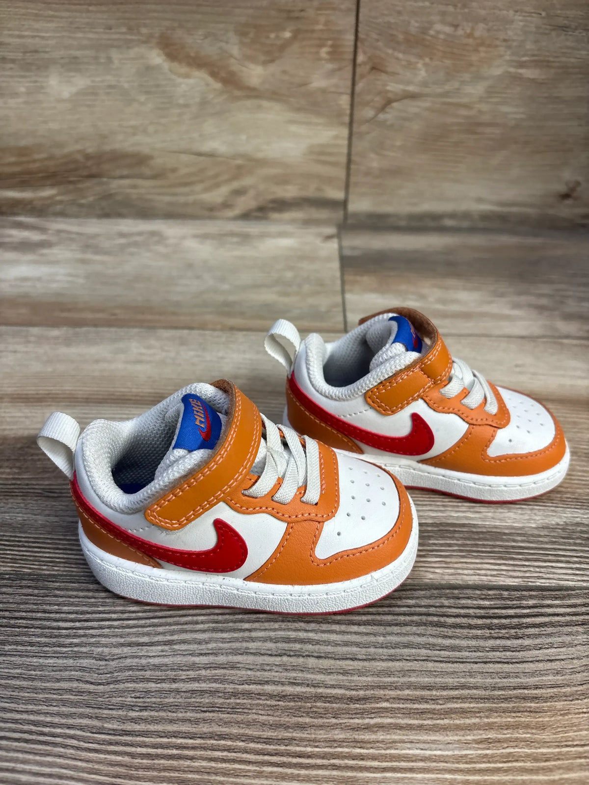 Three quarter view of Nike Court Borough Low 2 TD Sail Hot Curry sneakers with white uppers, orange overlays, and red swooshes