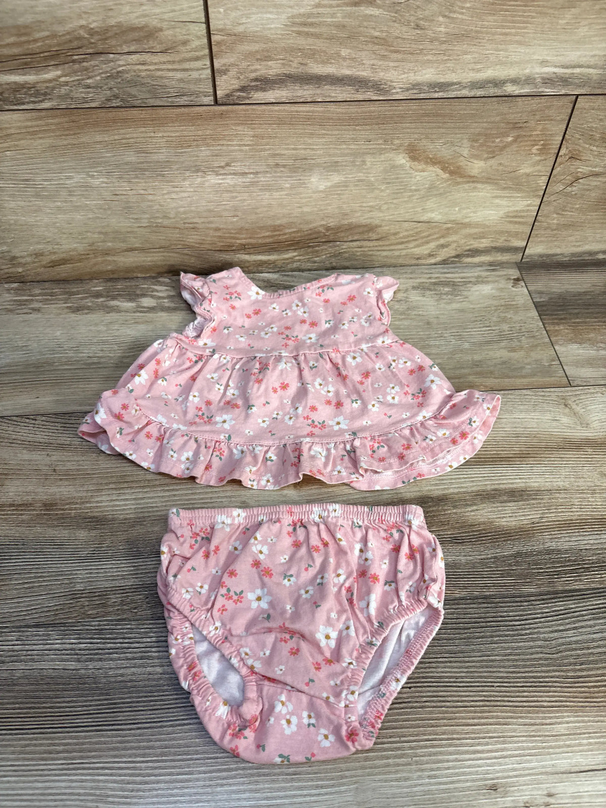 Front view of pink Just One You peplum top and bloomers set showcasing floral print and ruffle details on wood-look floor