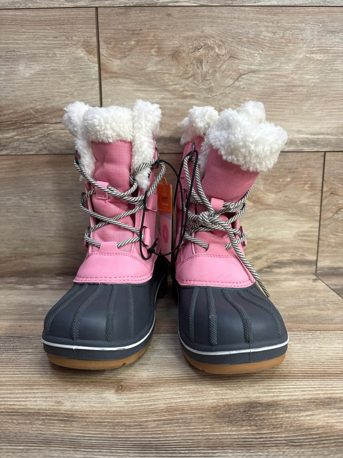 Pink and gray kids winter snow boots with faux fur lining and rubber soles on wood floor