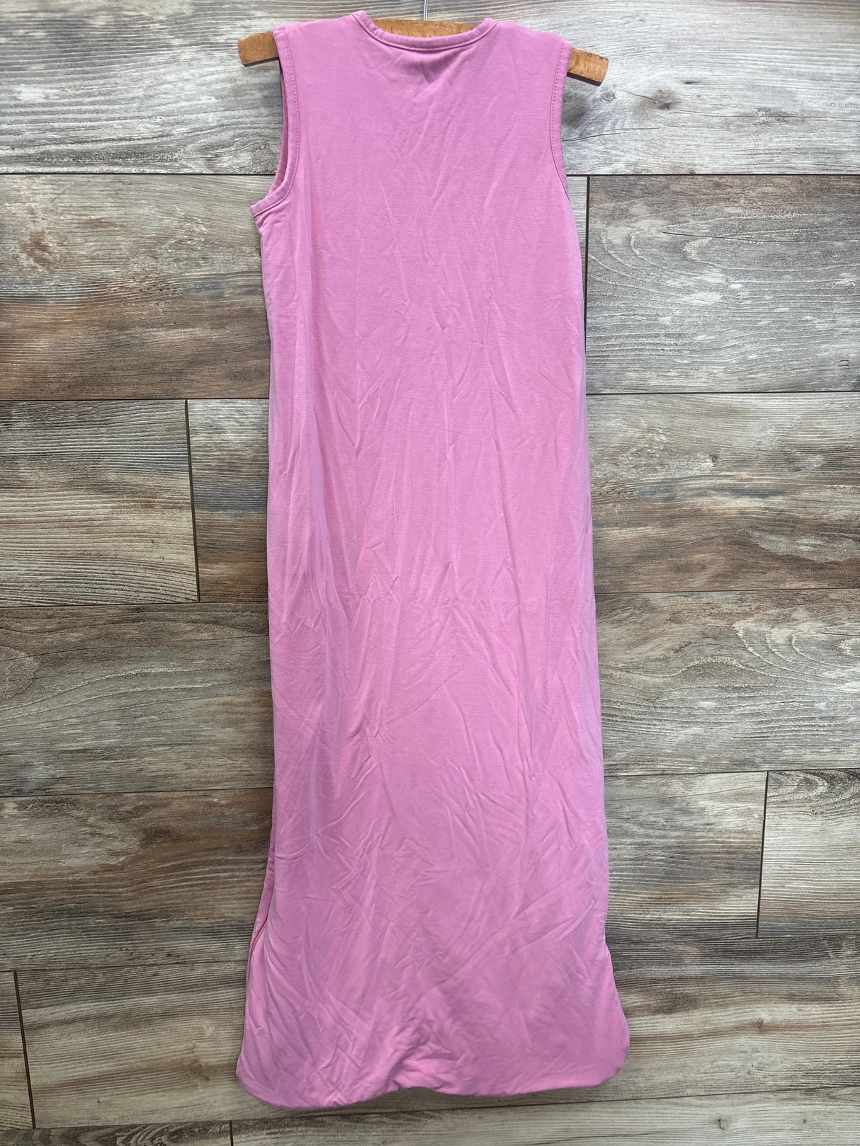 Back view of Quince bamboo sleep bag 2.5 TOG in Misty Rose, sleeveless, on wooden hanger over wood-plank background