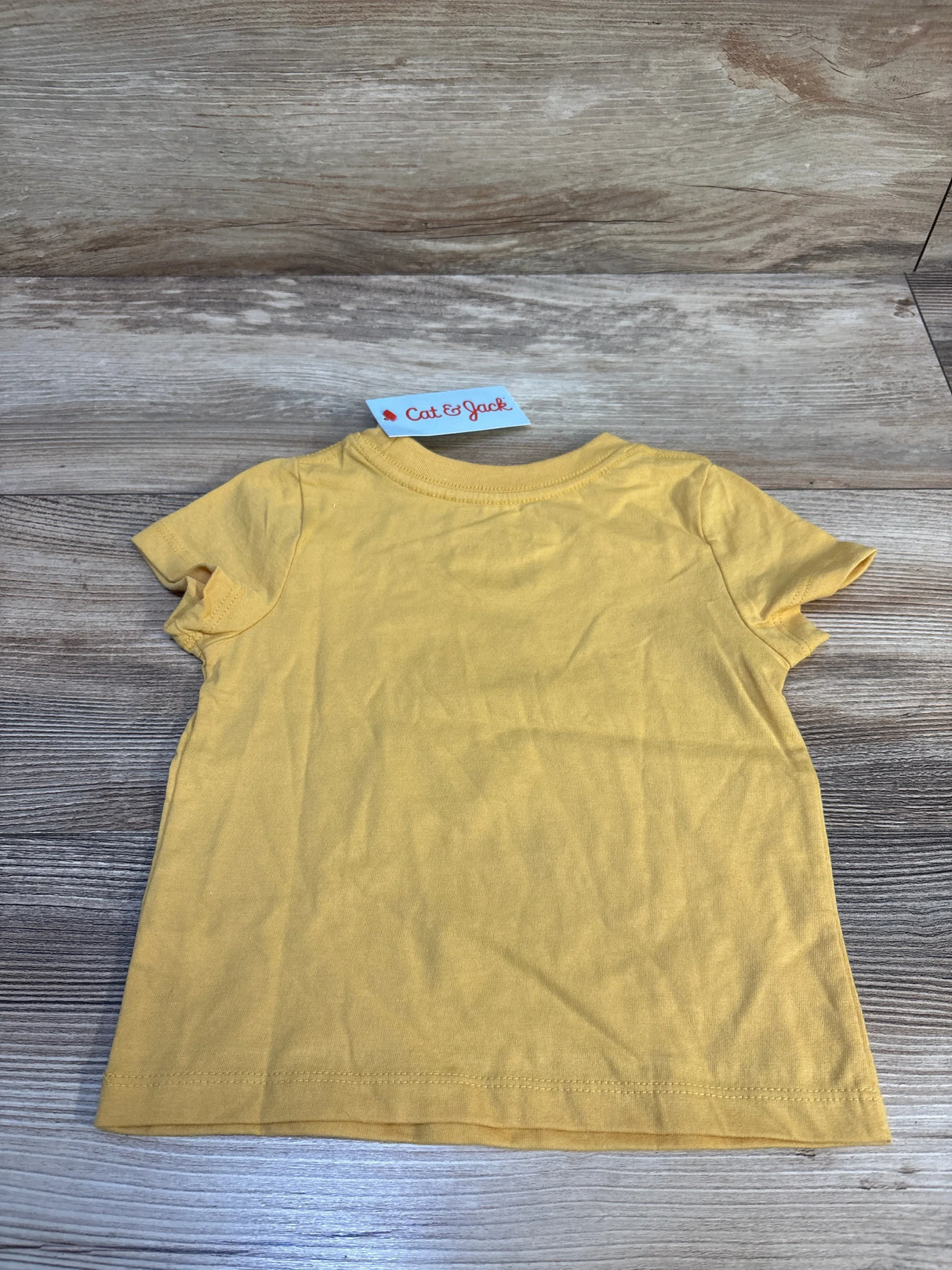 Yellow short sleeve toddler t-shirt on wood background, Cat & Jack tag visible