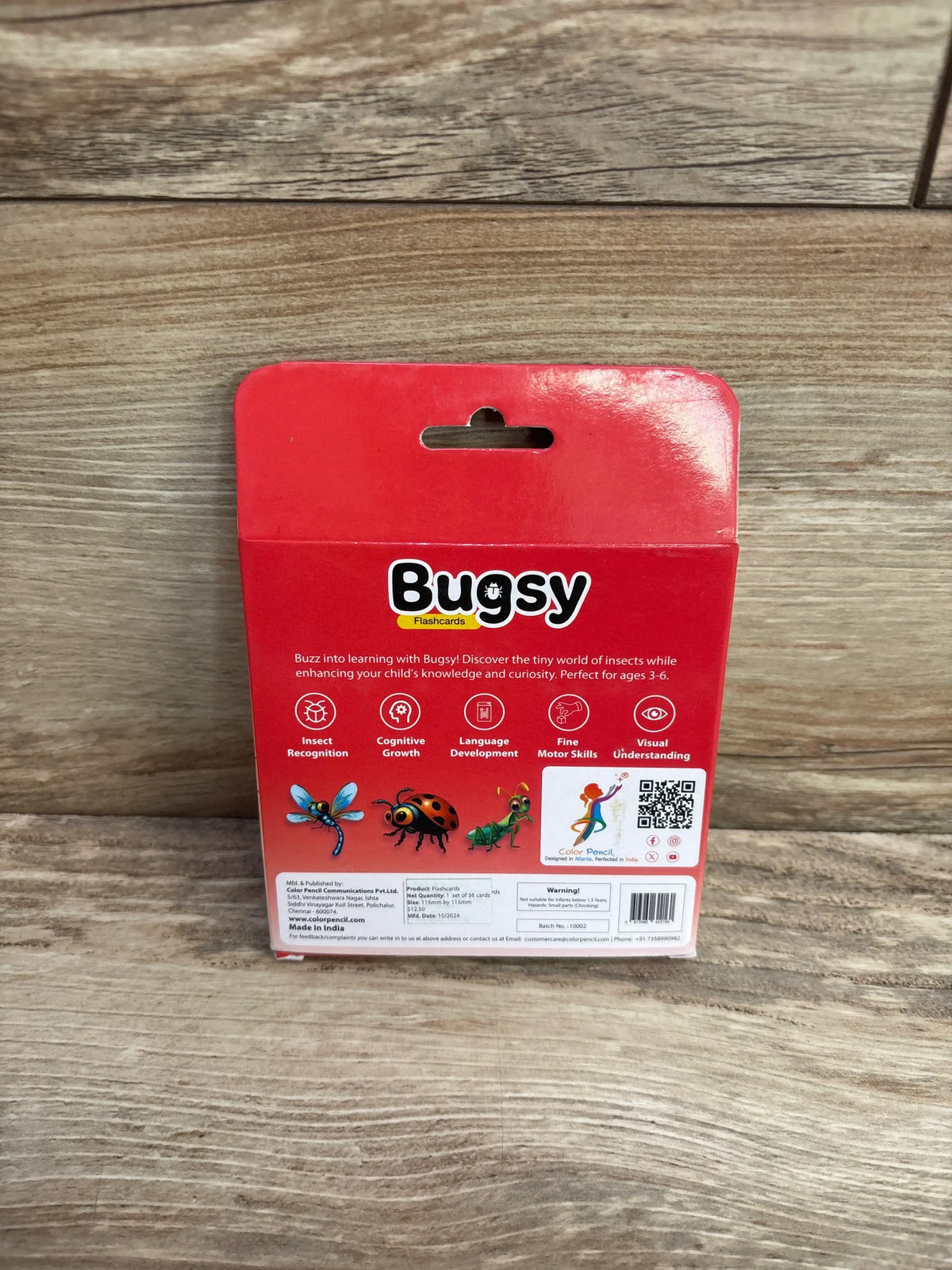 Back of Bugsy insect flashcards box for kids, showing educational benefits on wood background
