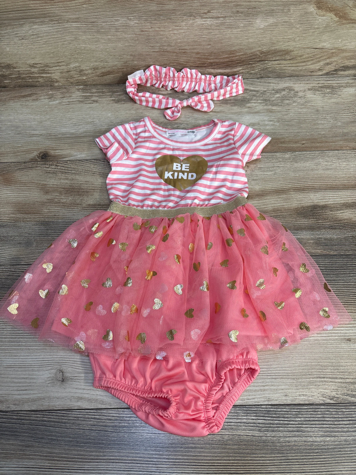 Pink and gold baby girl outfit with striped romper, tutu skirt, matching headband, and "Be Kind" heart graphic.