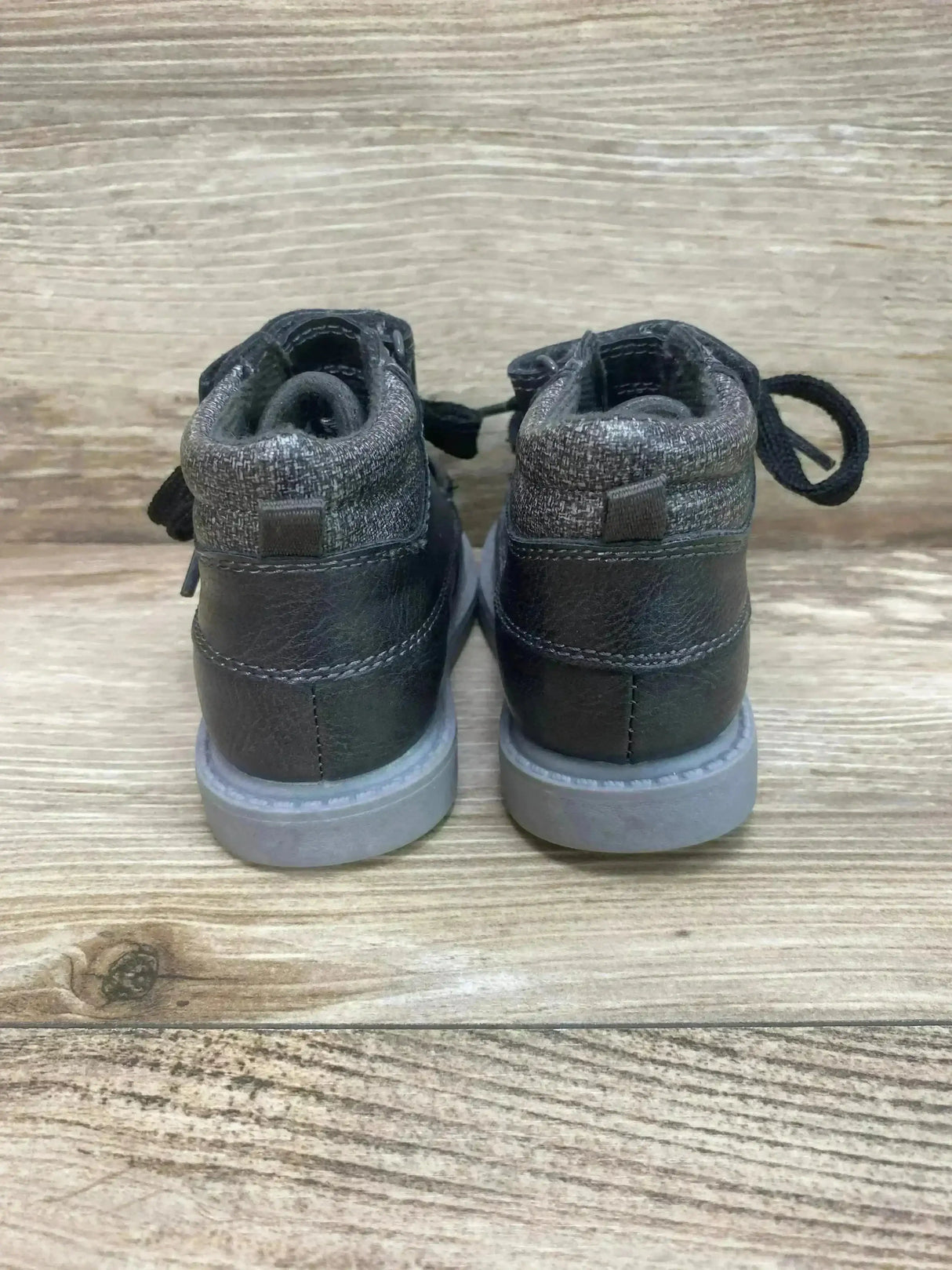 Rear view of Carter’s Norman toddler grey ankle boots showing padded knit collar, heel pull tab, faux-leather upper and grey sole on wood floor